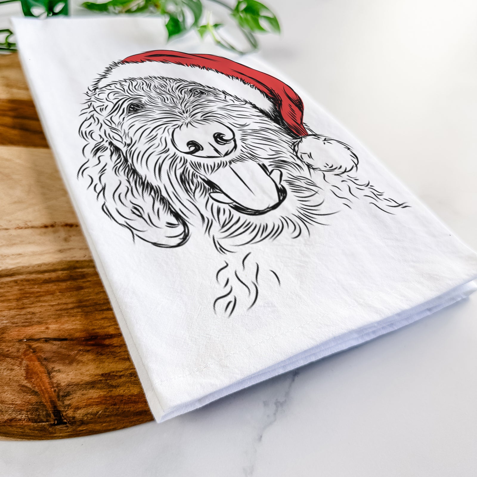 Hand-drawn sketch of Dixie the Doodle wearing a Santa hat on a tea towel