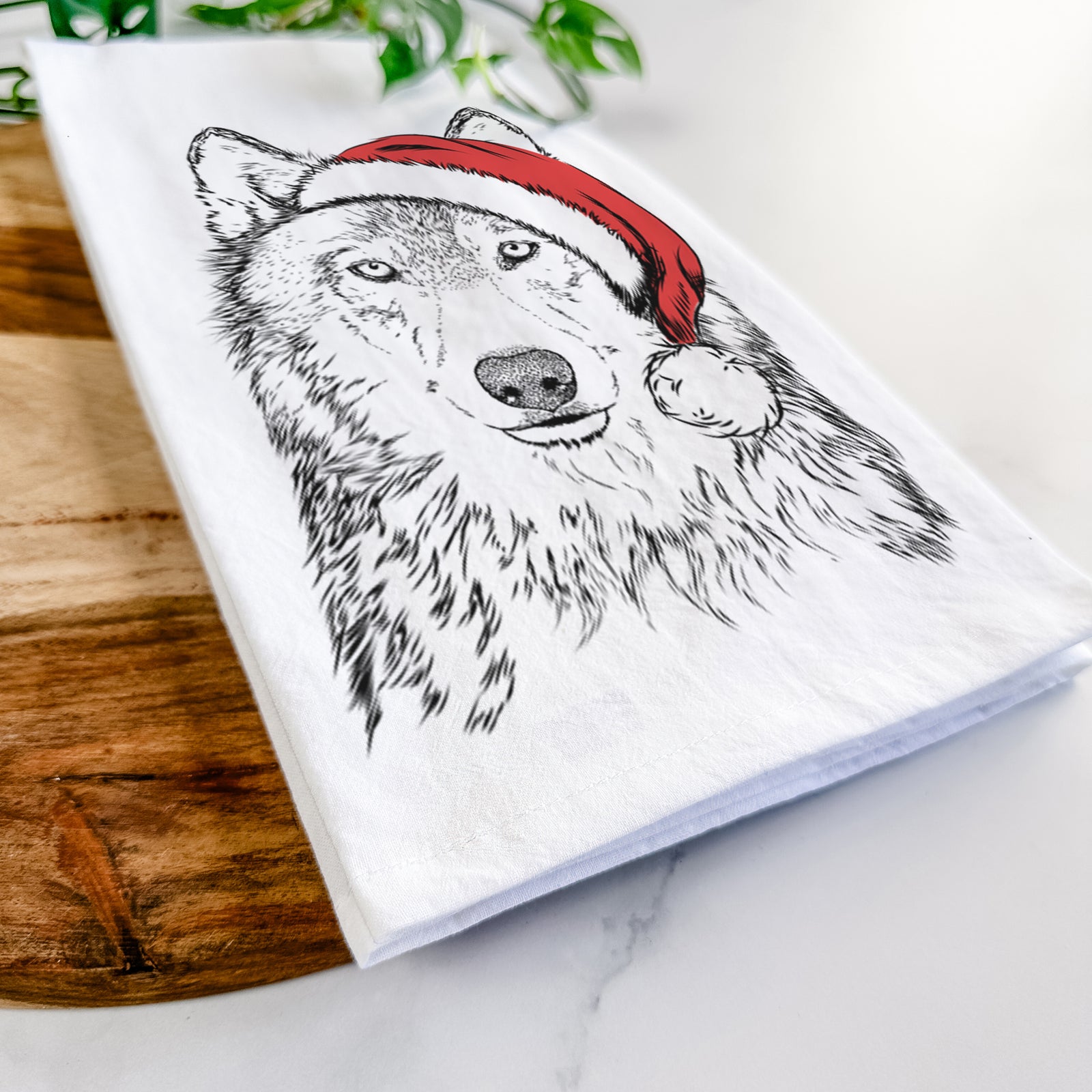Hand-drawn sketch of Django the Grey Wolf wearing a Santa hat on a tea towel