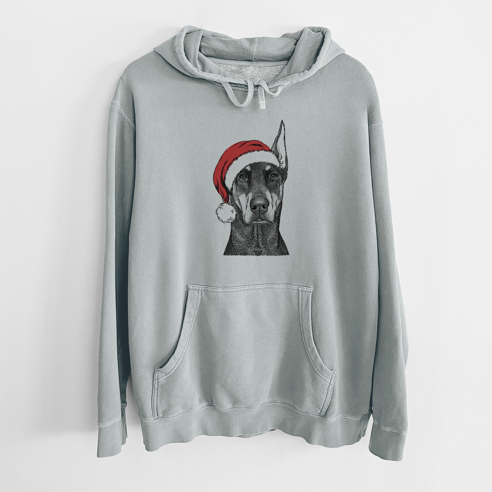 Hand-drawn sketch of Drake the Doberman Pinscher wearing a Santa hat on a Sage Unisex pigment dyed hoodie