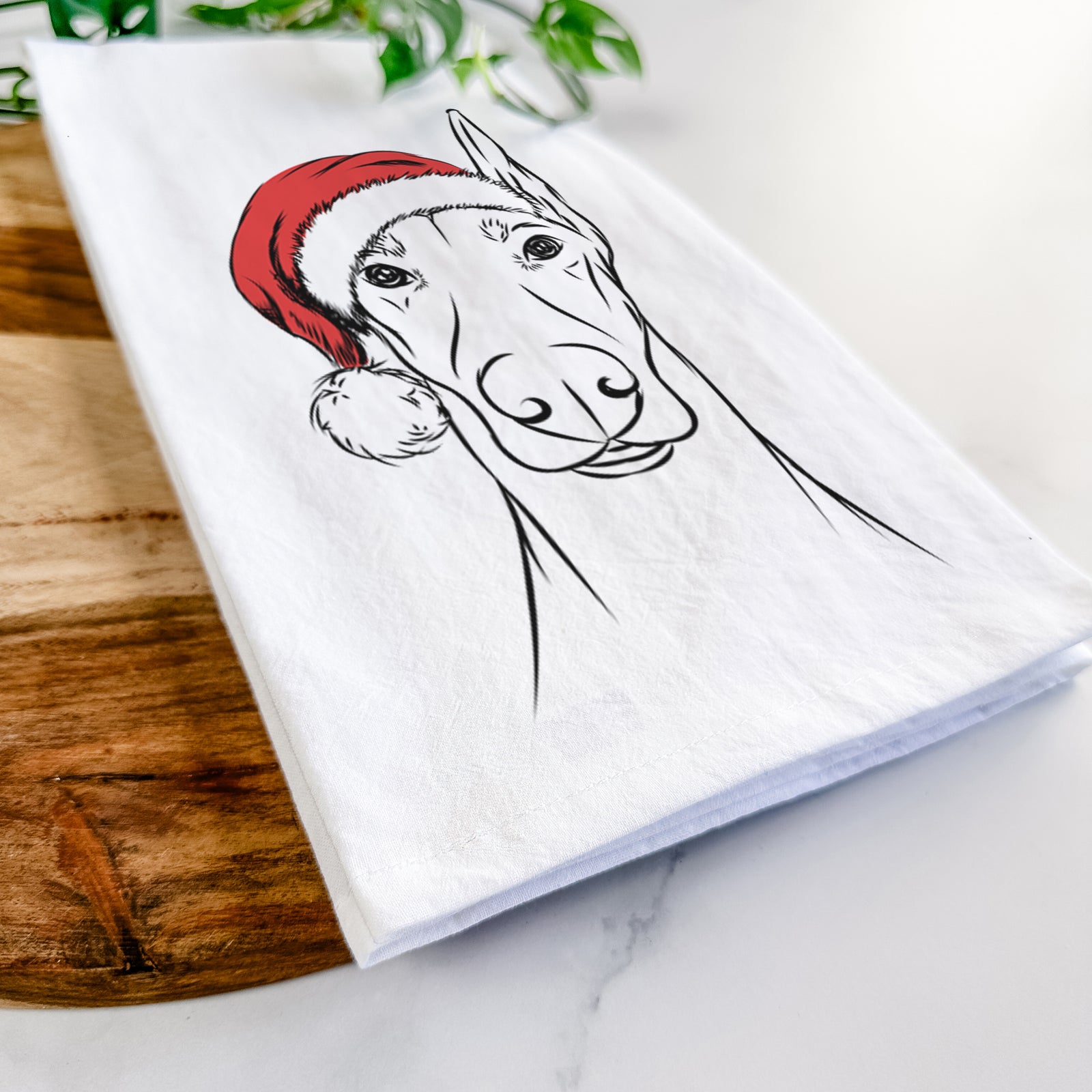 Hand-drawn sketch of Duke the Doberman Pinscher wearing a Santa hat on a tea towel