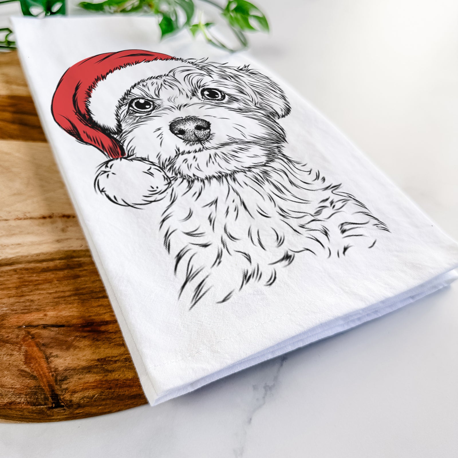 Hand-drawn sketch of Elliott the Yorkiepoo wearing a Santa hat on a tea towel