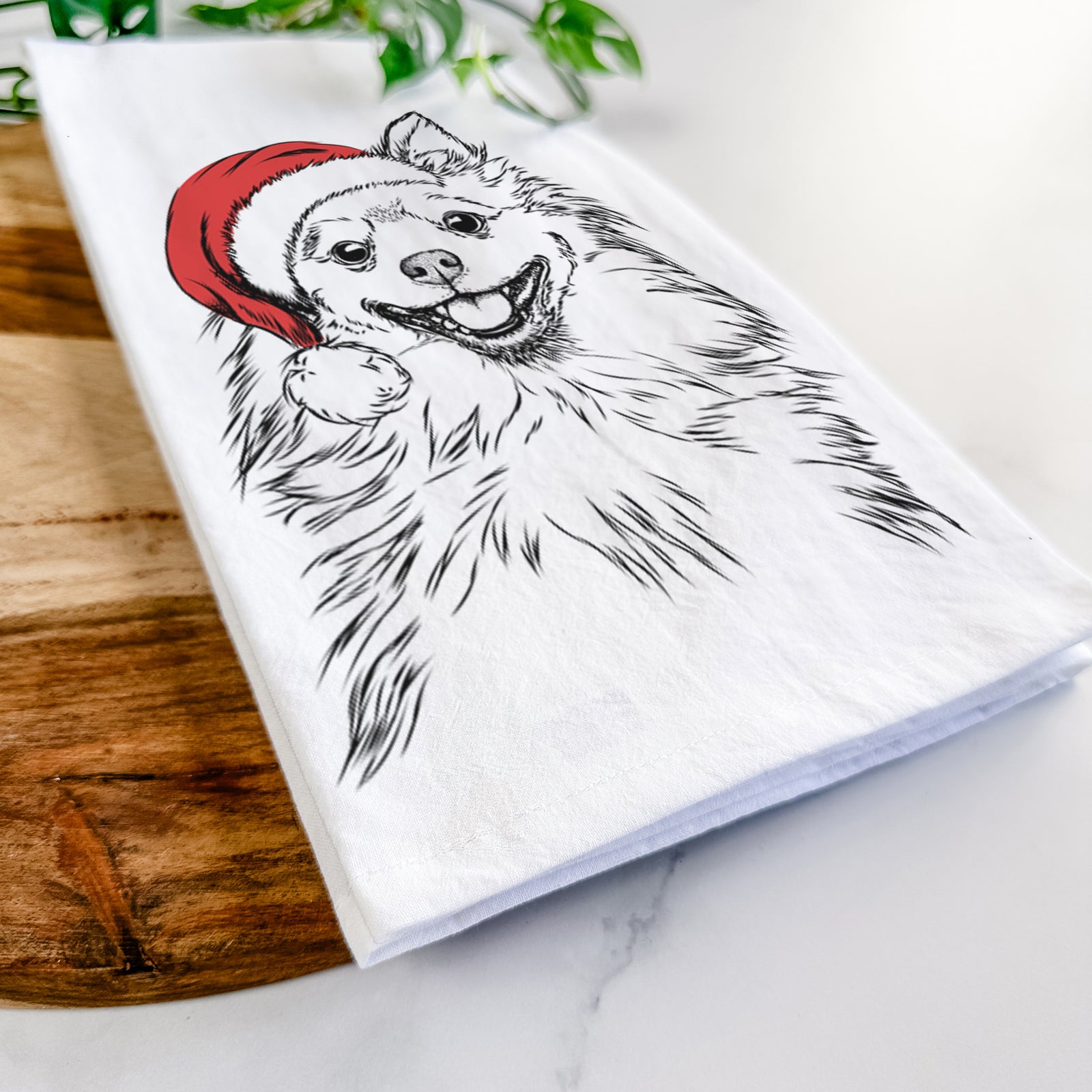 Hand-drawn sketch of Fibi the Spitz wearing a Santa hat on a tea towel