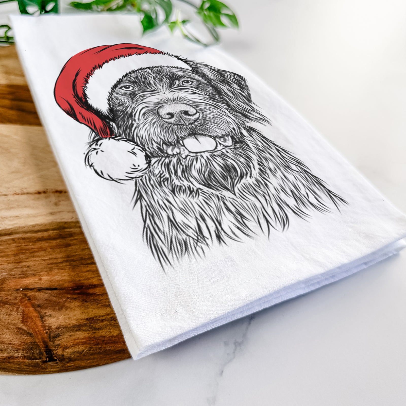 Hand-drawn sketch of Fletcher the Wirehaired Pointing Griffon wearing a Santa hat on a tea towel