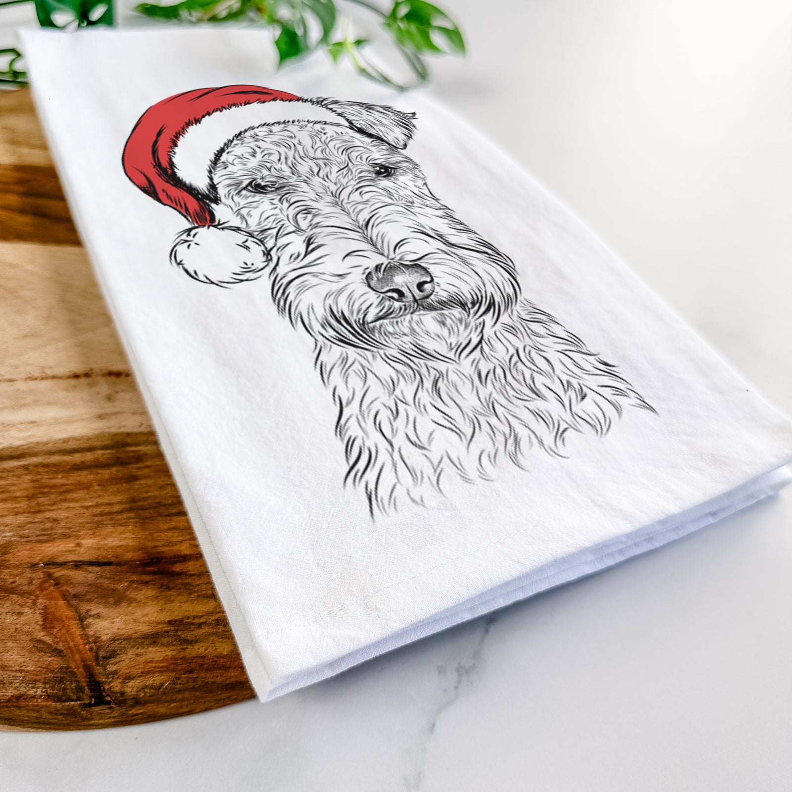 Hand-drawn sketch of Frida the Lakeland Terrier wearing a Santa hat on a tea towel