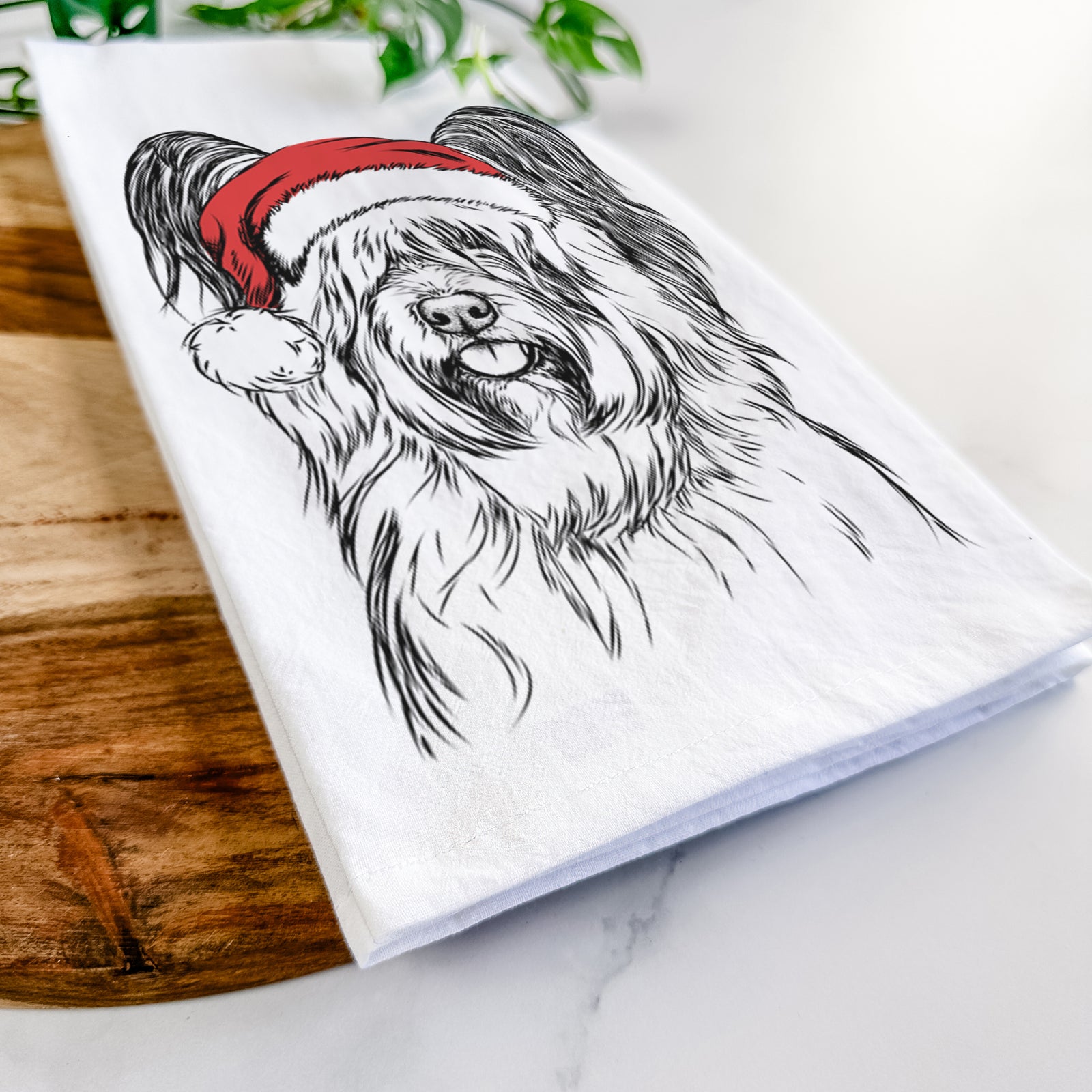 Hand-drawn sketch of Gideon the Skye Terrier wearing a Santa hat on a tea towel