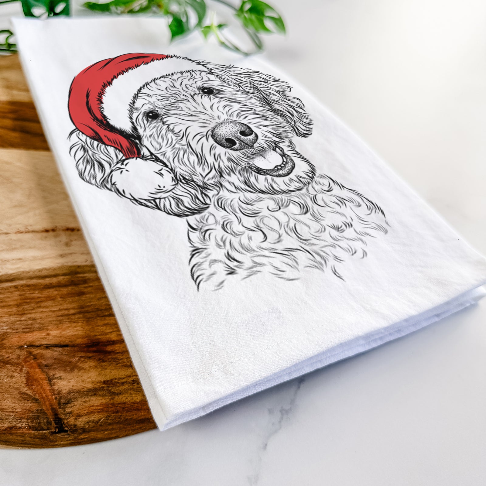Hand-drawn sketch of Gizmo the Goldendoodle wearing a Santa hat on a tea towel