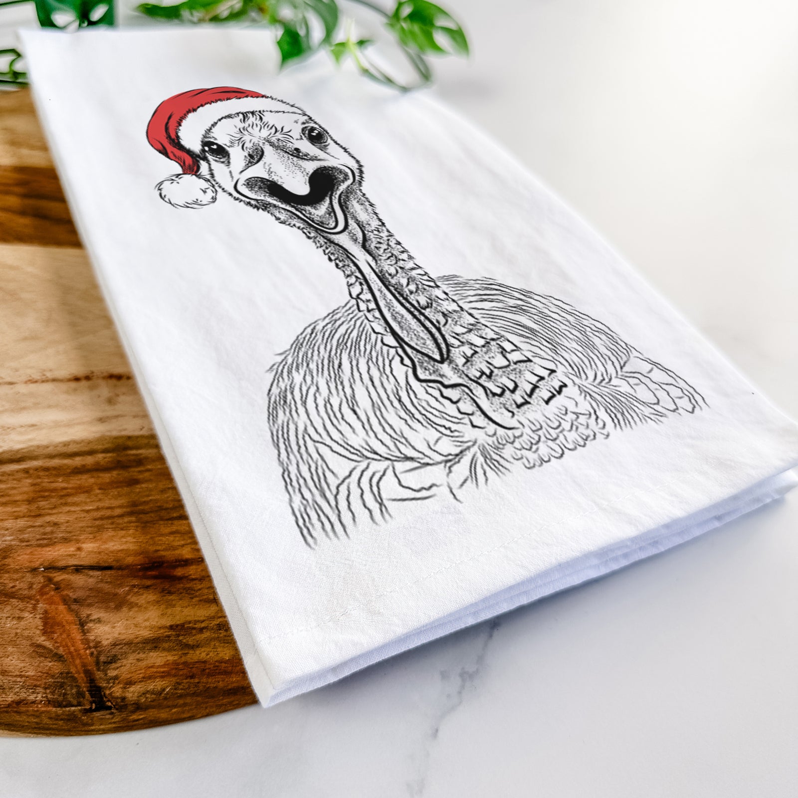 Hand-drawn sketch of Gobble the Turkey wearing a Santa hat on a tea towel