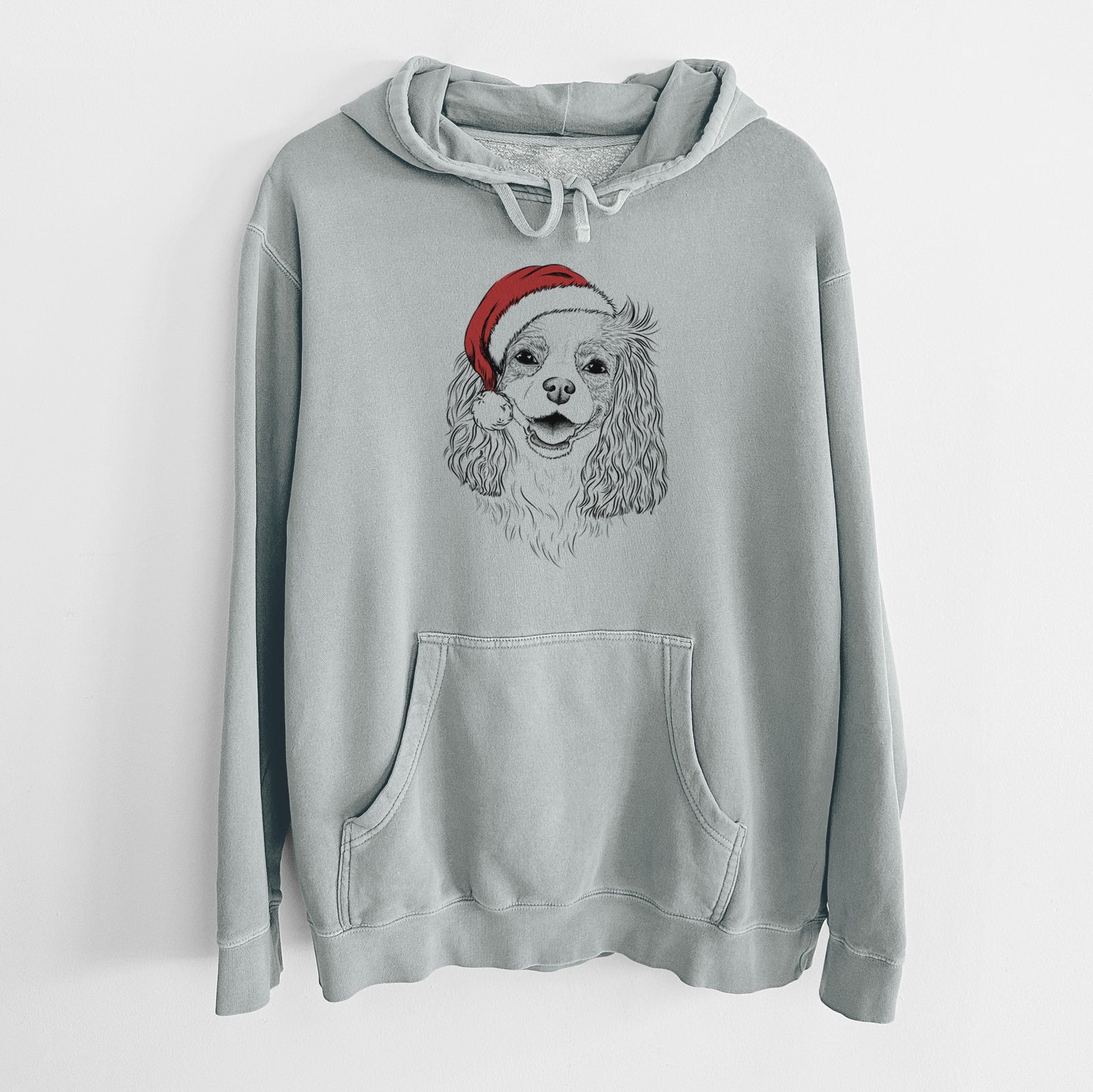 Hand-drawn sketch of Halley Comet the Cavalier King Charles Spaniel wearing a Santa hat on a Sage Unisex pigment dyed hoodie
