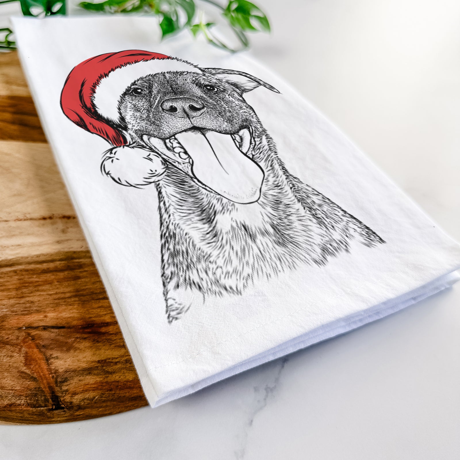 Hand-drawn sketch of Harley the Pitbull Mix wearing a Santa hat on a tea towel