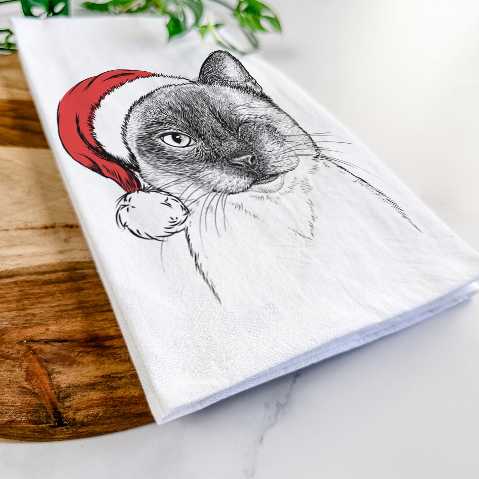 Hand-drawn sketch of Hoggle the Siamese Cat wearing a Santa hat on a tea towel
