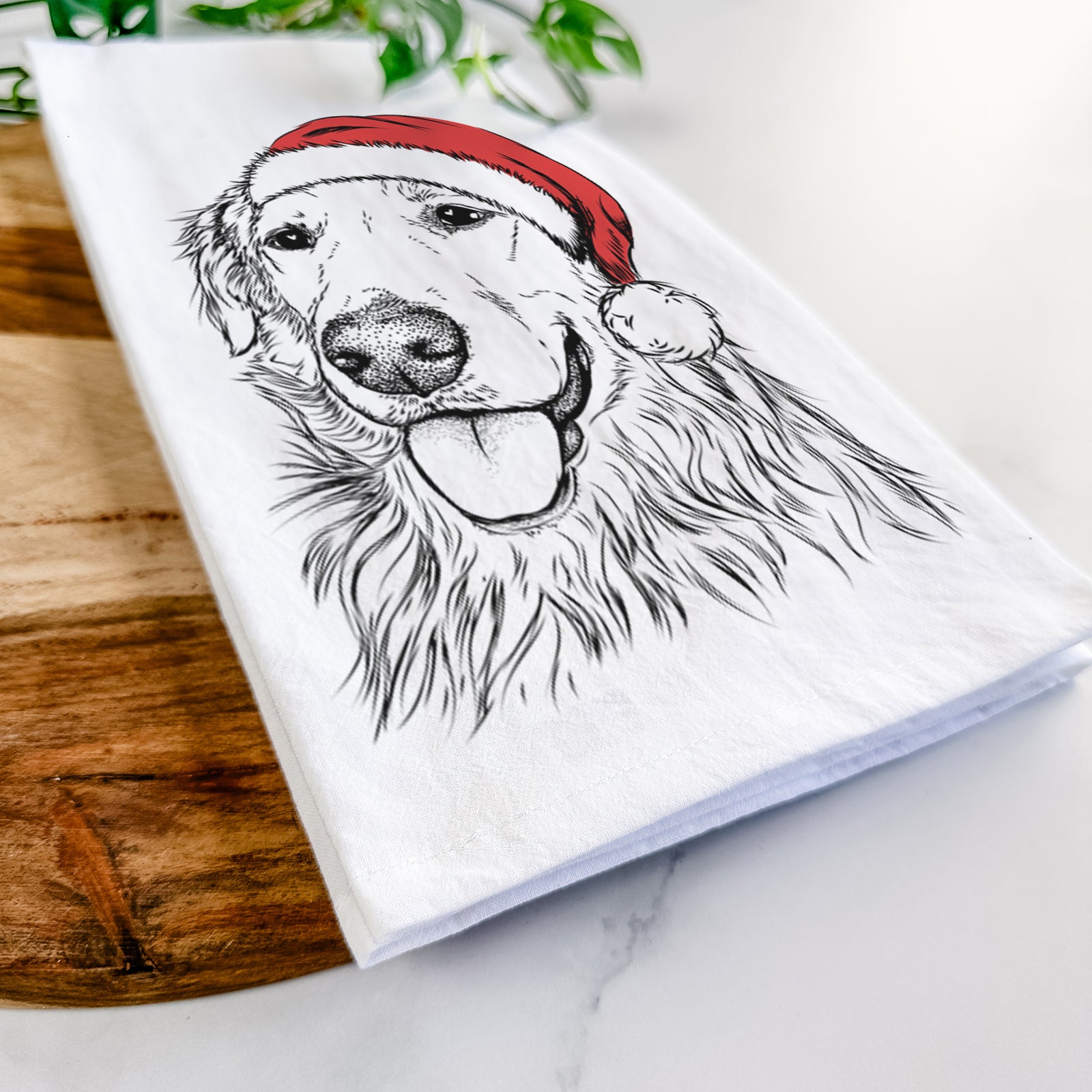Hand-drawn sketch of Hopper the Golden Retriever wearing a Santa hat on a tea towel