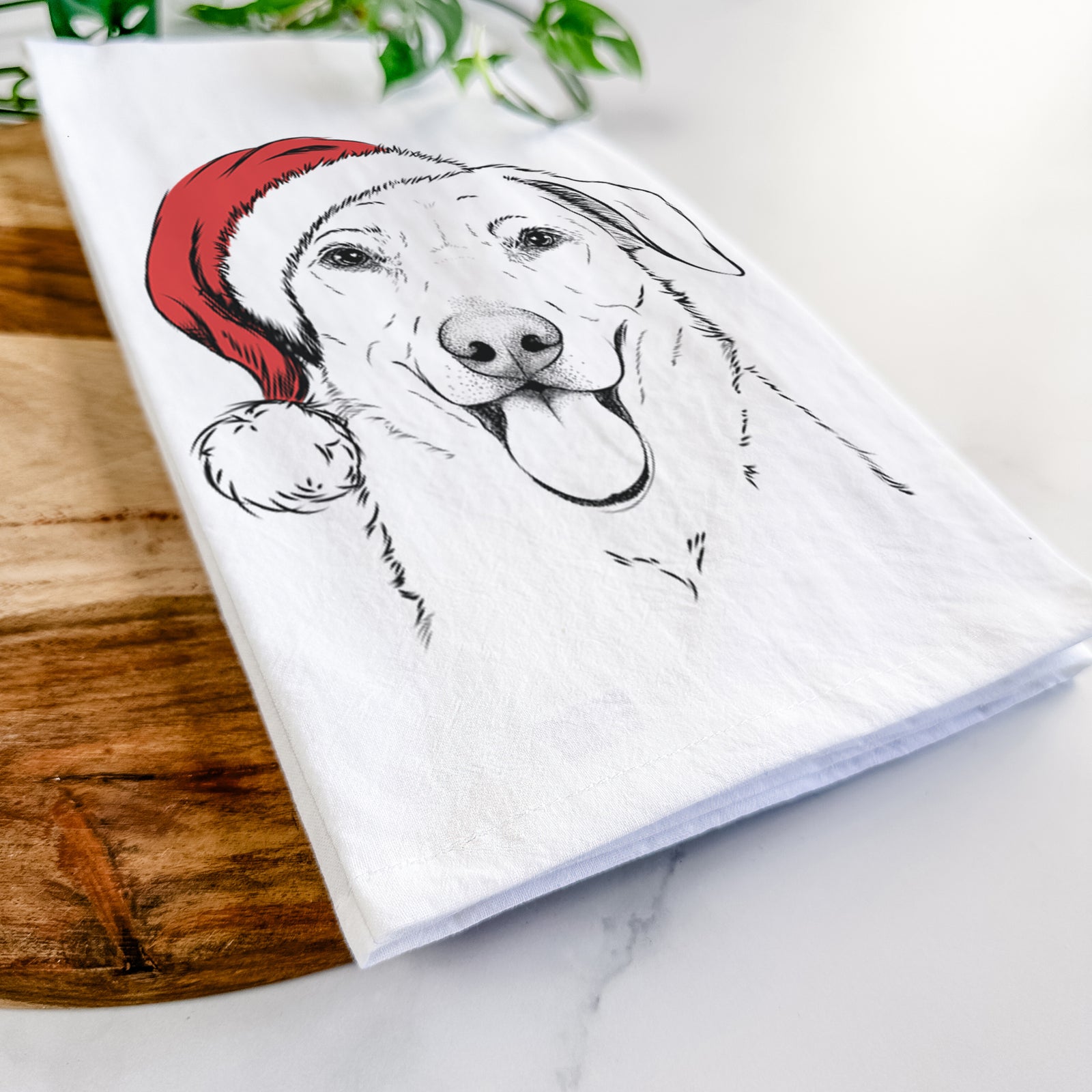 Hand-drawn sketch of Hudson the Shepherd wearing a Santa hat on a tea towel