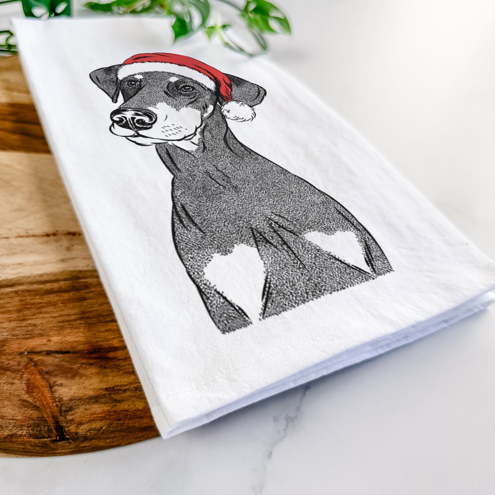 Hand-drawn sketch of Iroh the Doberman Pinscher wearing a Santa hat on a tea towel