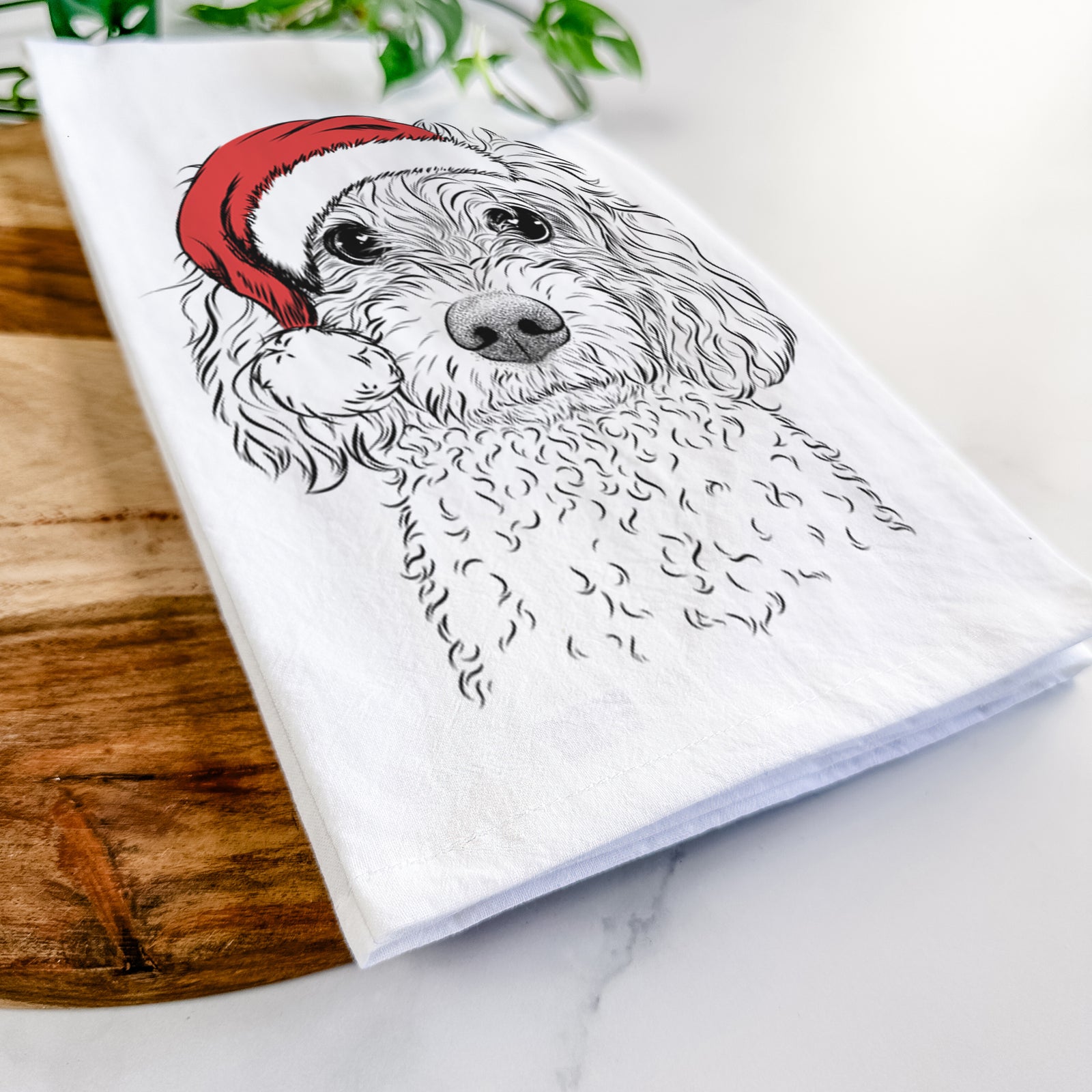 Hand-drawn sketch of Izzie the Cavachon wearing a Santa hat on a tea towel
