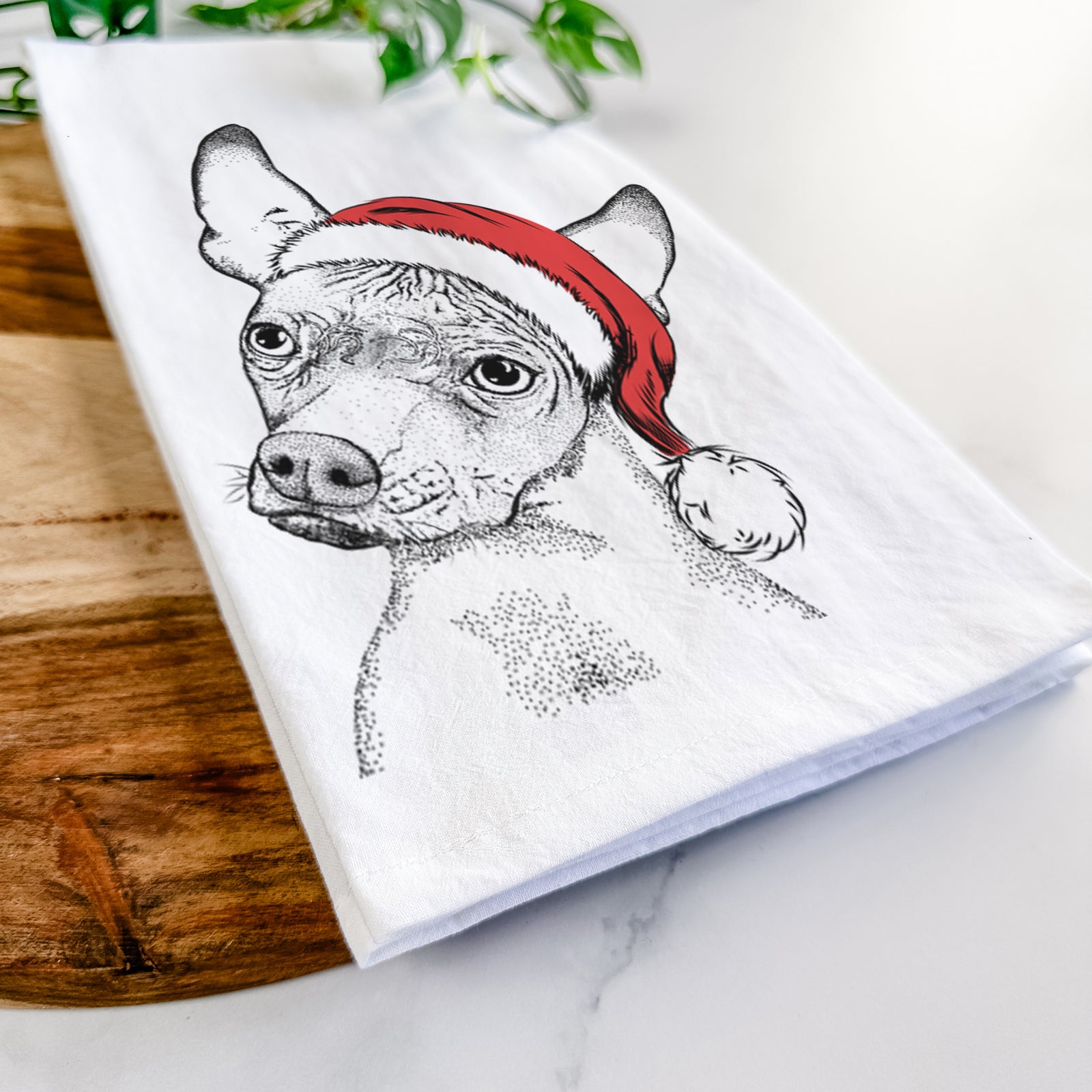 Hand-drawn sketch of Kahlo the Xoloitzcuintli wearing a Santa hat on a tea towel