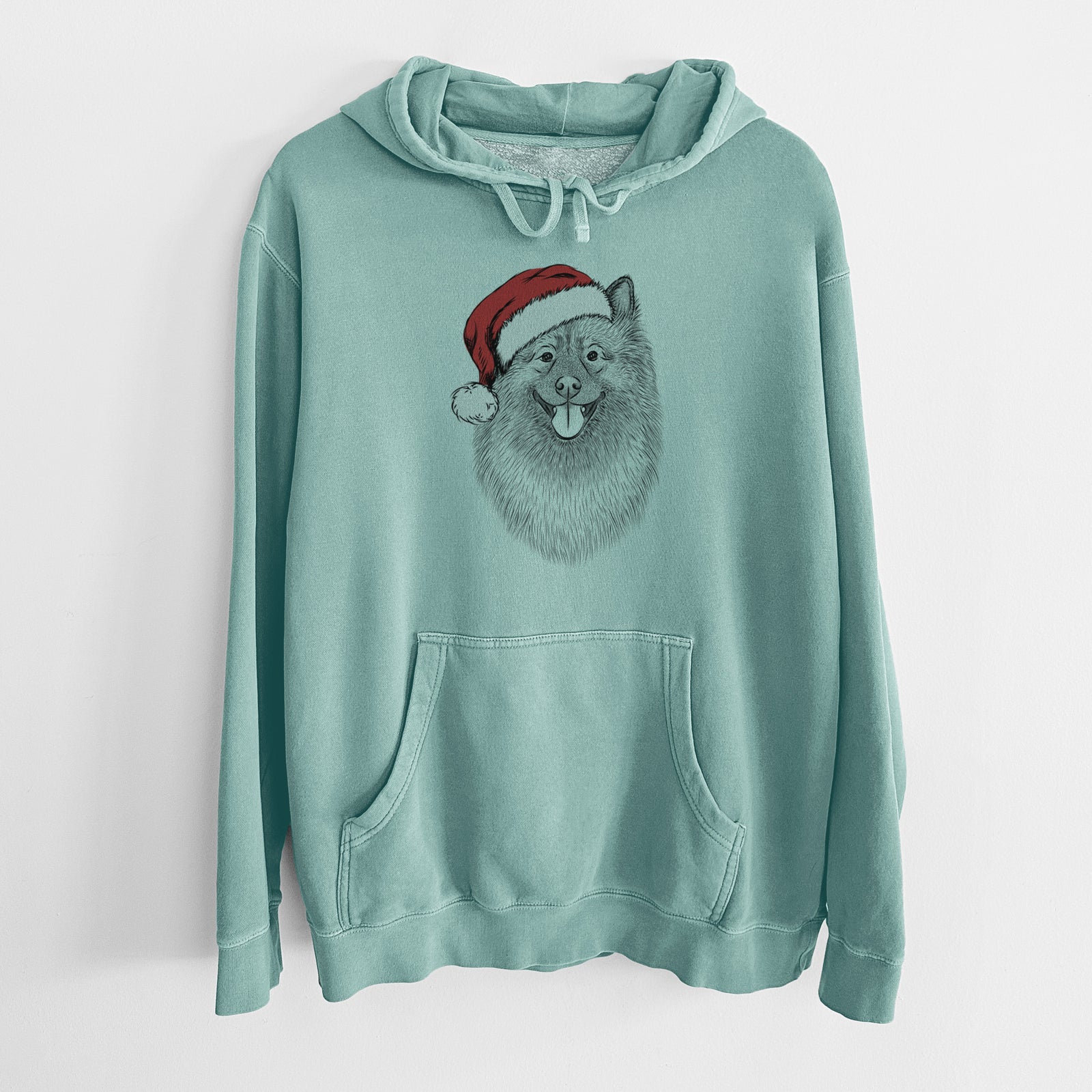 Hand-drawn sketch of Kai the Keeshond wearing a Santa hat on a Mint Unisex pigment dyed hoodie