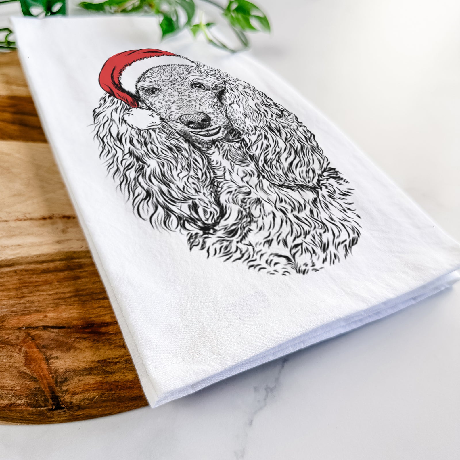 Hand-drawn sketch of Kenna the Standard Poodle wearing a Santa hat on a tea towel