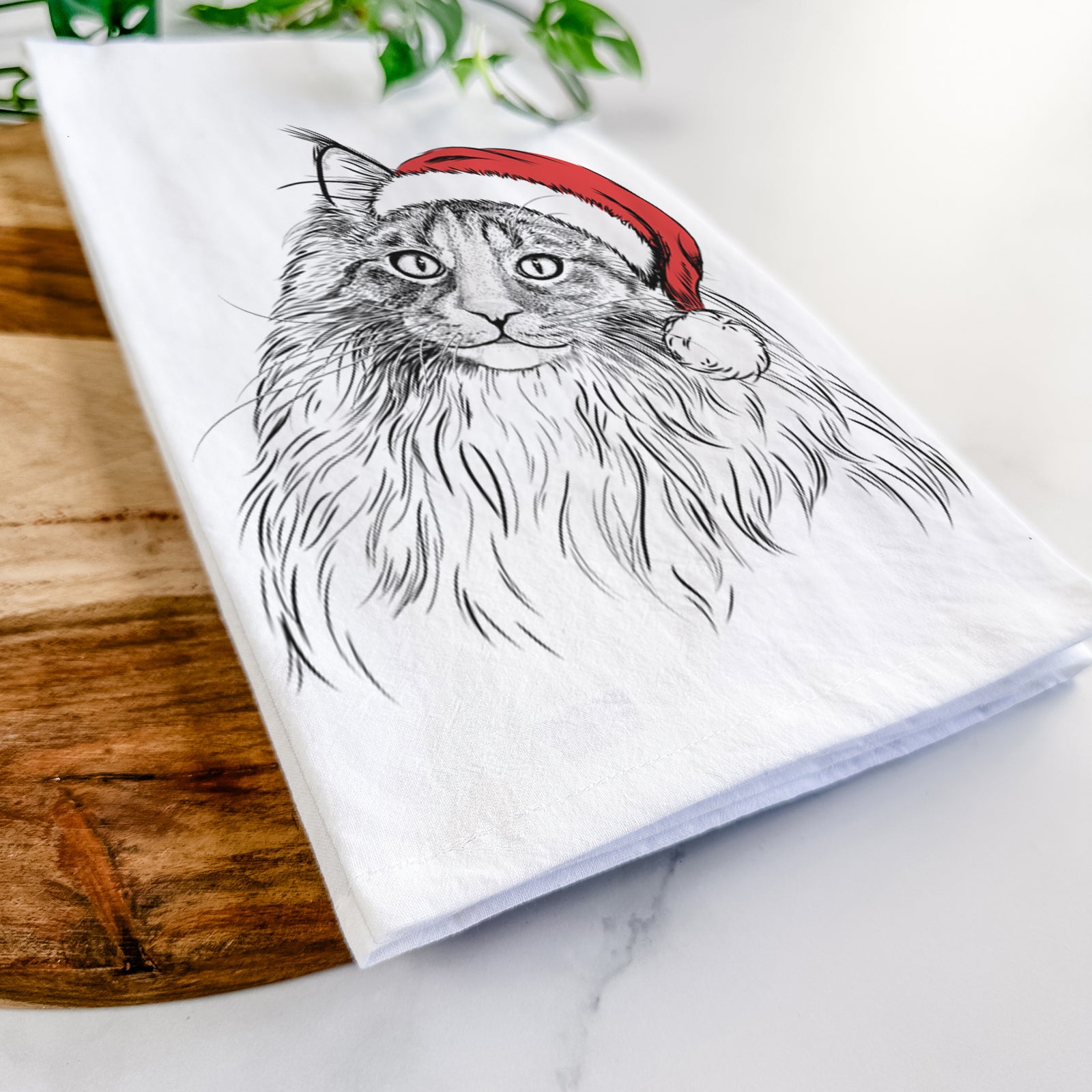 Hand-drawn sketch of Kiki the Maine Coon Cat wearing a Santa hat on a tea towel