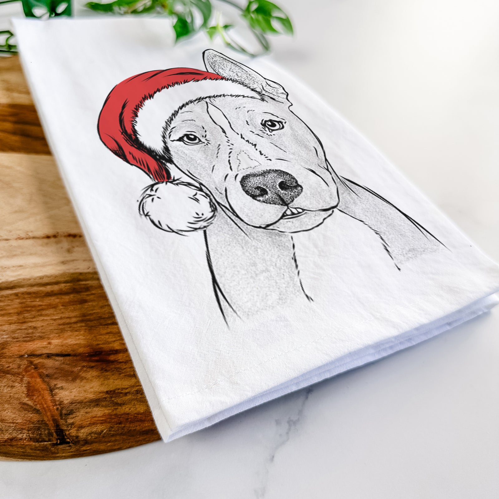 Hand-drawn sketch of Kisses the Pitbull wearing a Santa hat on a tea towel