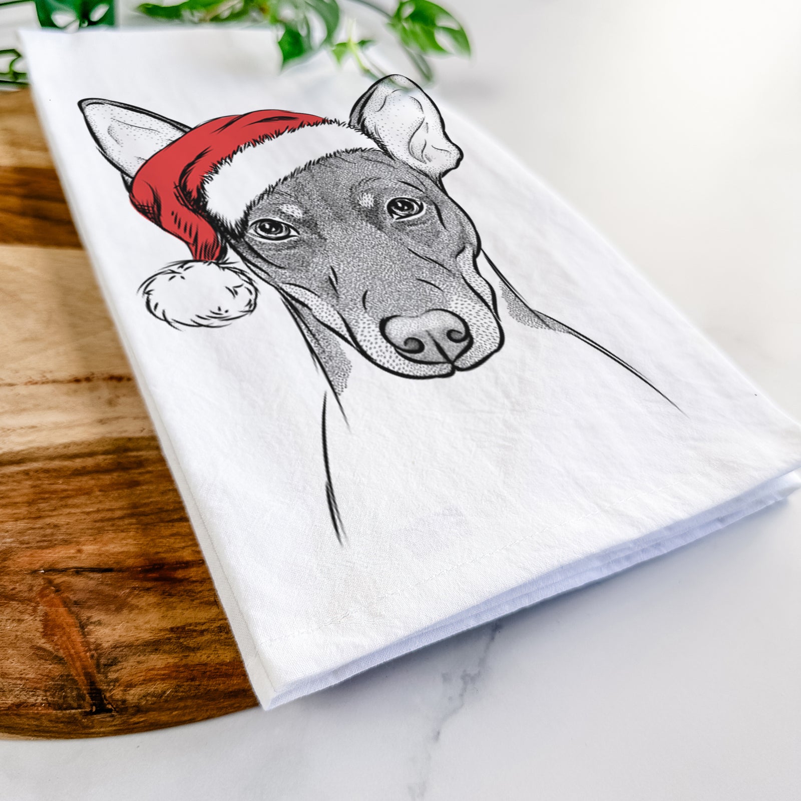 Hand-drawn sketch of Knox the Rat Terrier wearing a Santa hat on a tea towel
