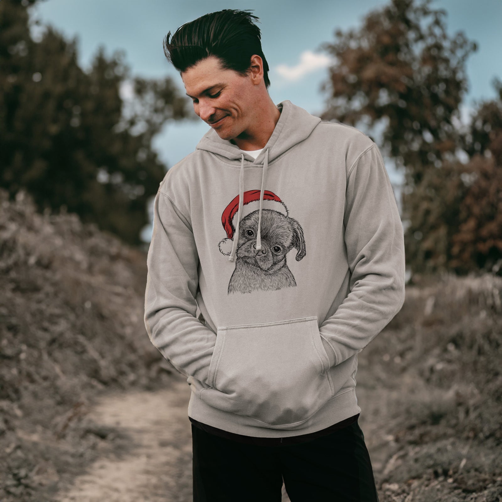 Hand-drawn sketch of Koko the Shih Tzu wearing a Santa hat on a Cement Unisex pigment dyed hoodie, worn by a man