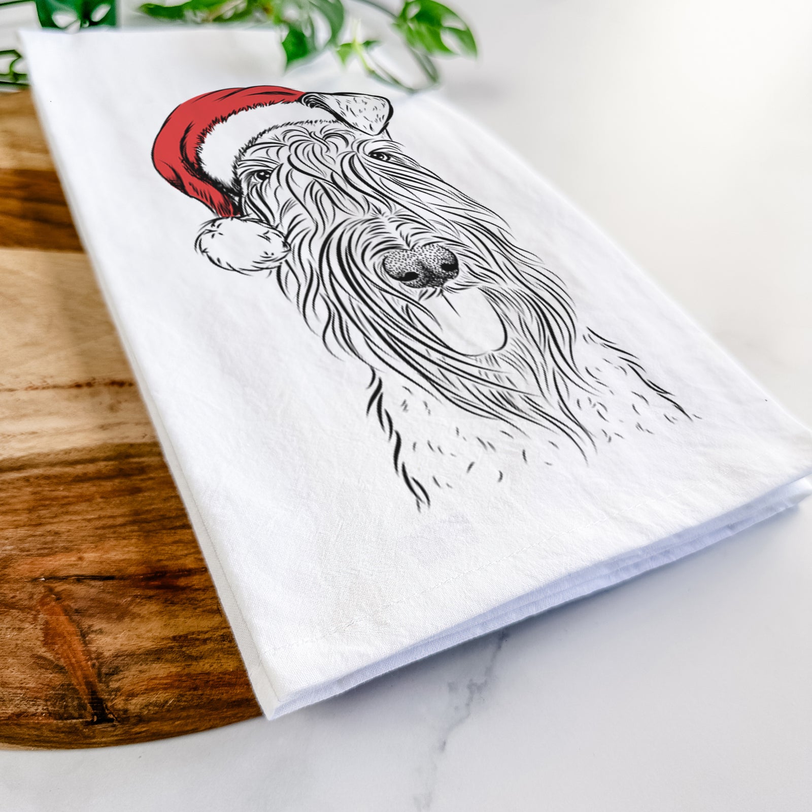 Hand-drawn sketch of Kricket the Kerry Blue Terrier wearing a Santa hat on a tea towel