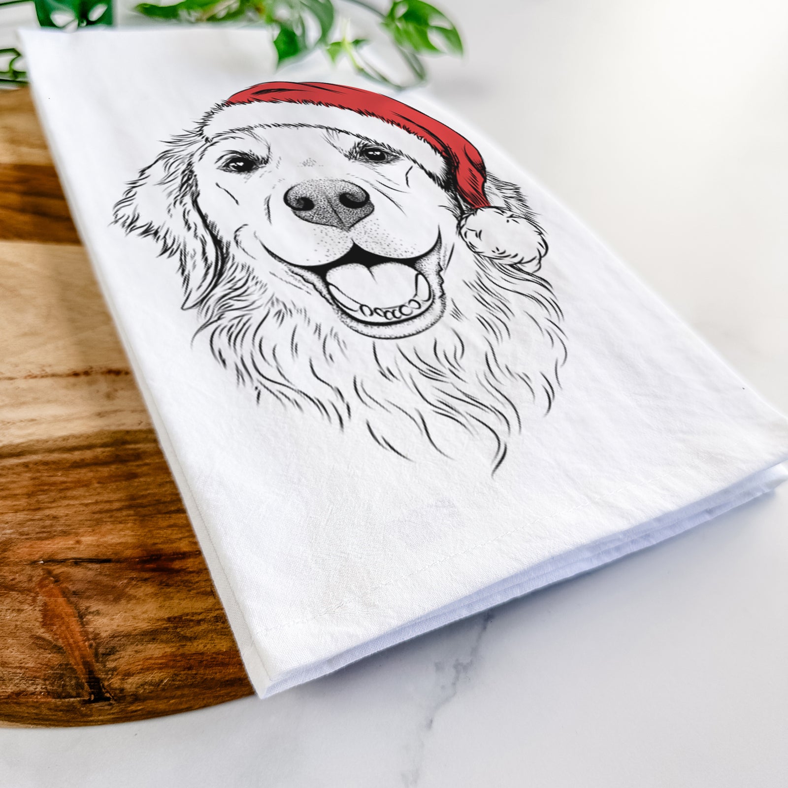 Hand-drawn sketch of Legend the Golden Retriever wearing a Santa hat on a tea towel