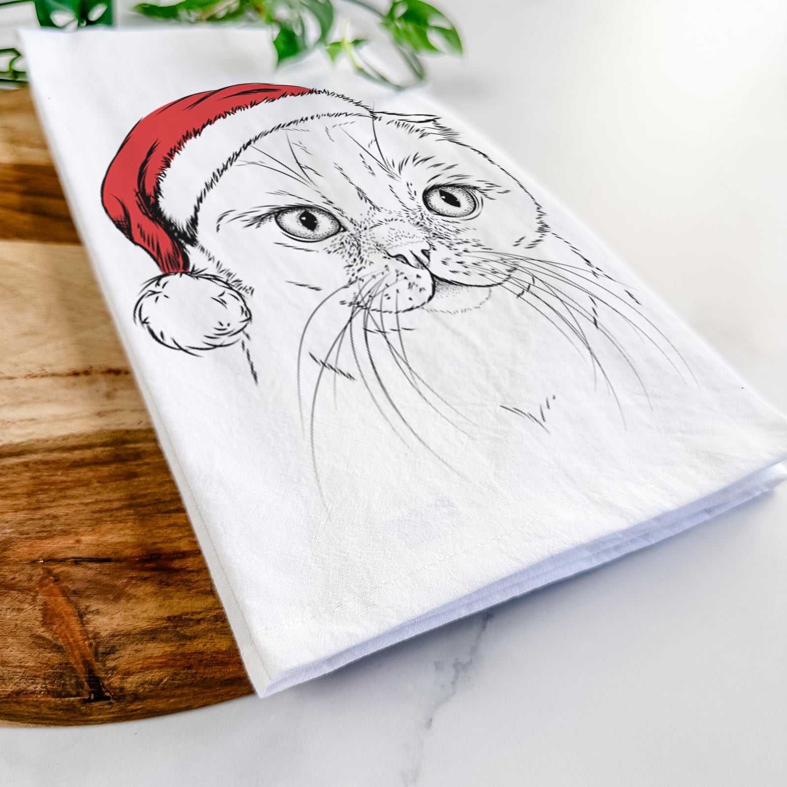 Hand-drawn sketch of Lina the Exotic Fold Cat wearing a Santa hat on a tea towel