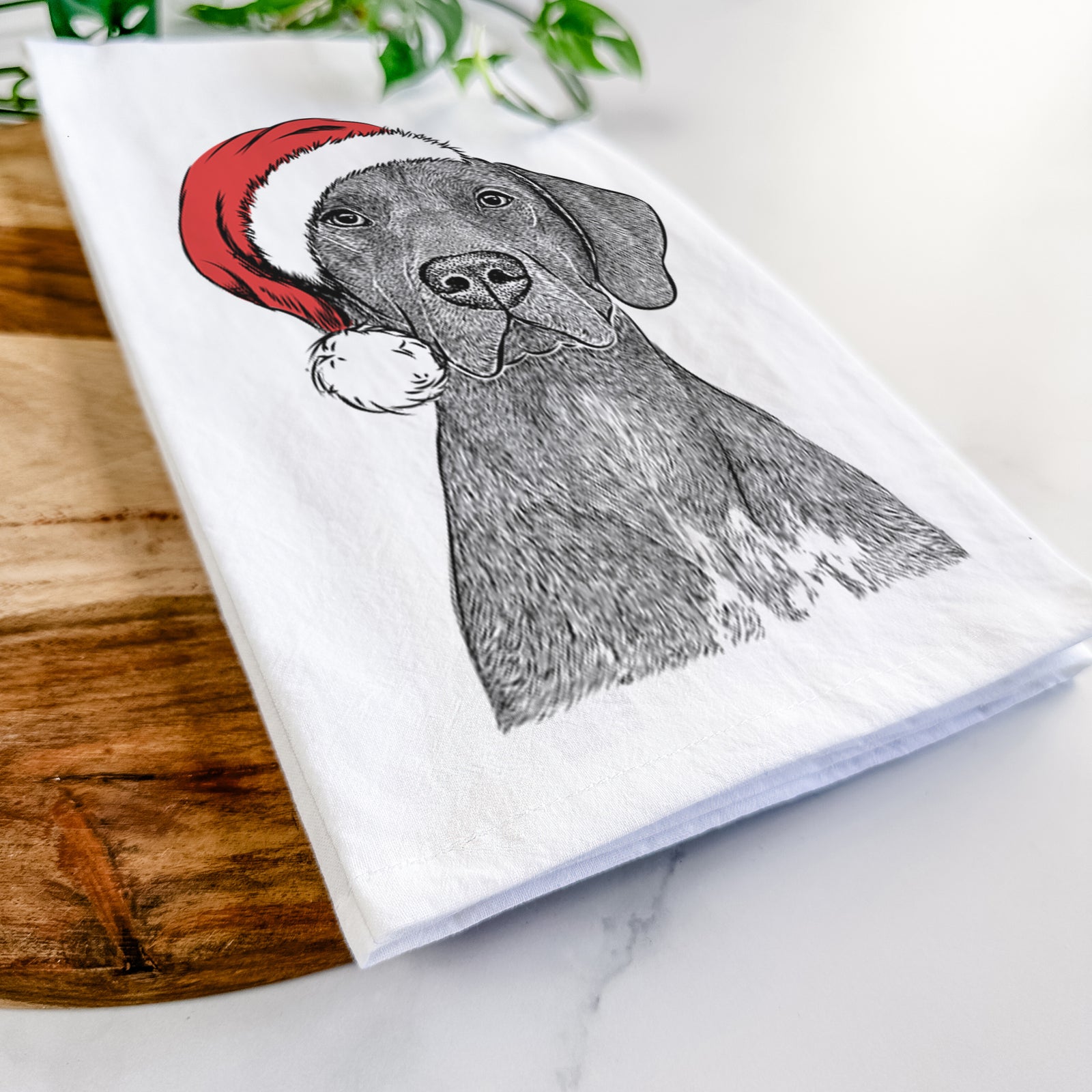 Hand-drawn sketch of Lucifer the German Shorthaired Pointer wearing a Santa hat on a tea towel