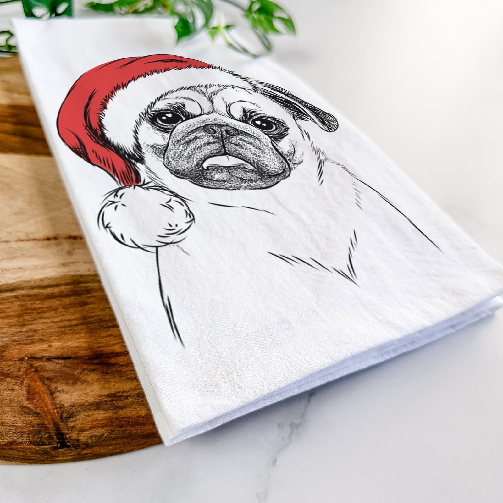 Hand-drawn sketch of Macy the Pug wearing a Santa hat on a tea towel