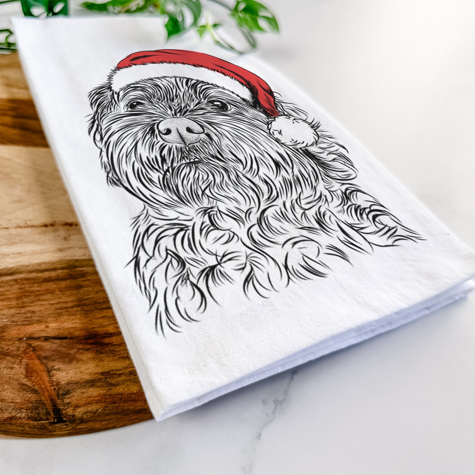 Hand-drawn sketch of Maggie Girl the Cockapoo wearing a Santa hat on a tea towel