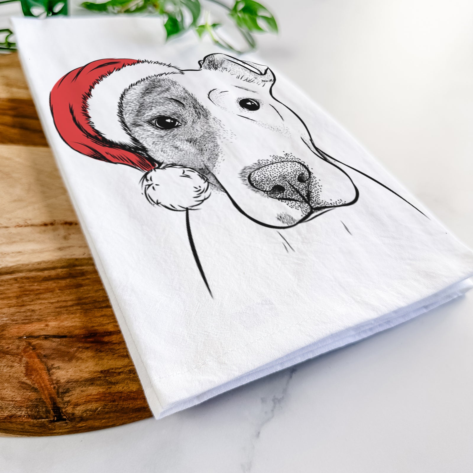 Hand-drawn sketch of Manchi the Pitbull Mix wearing a Santa hat on a tea towel