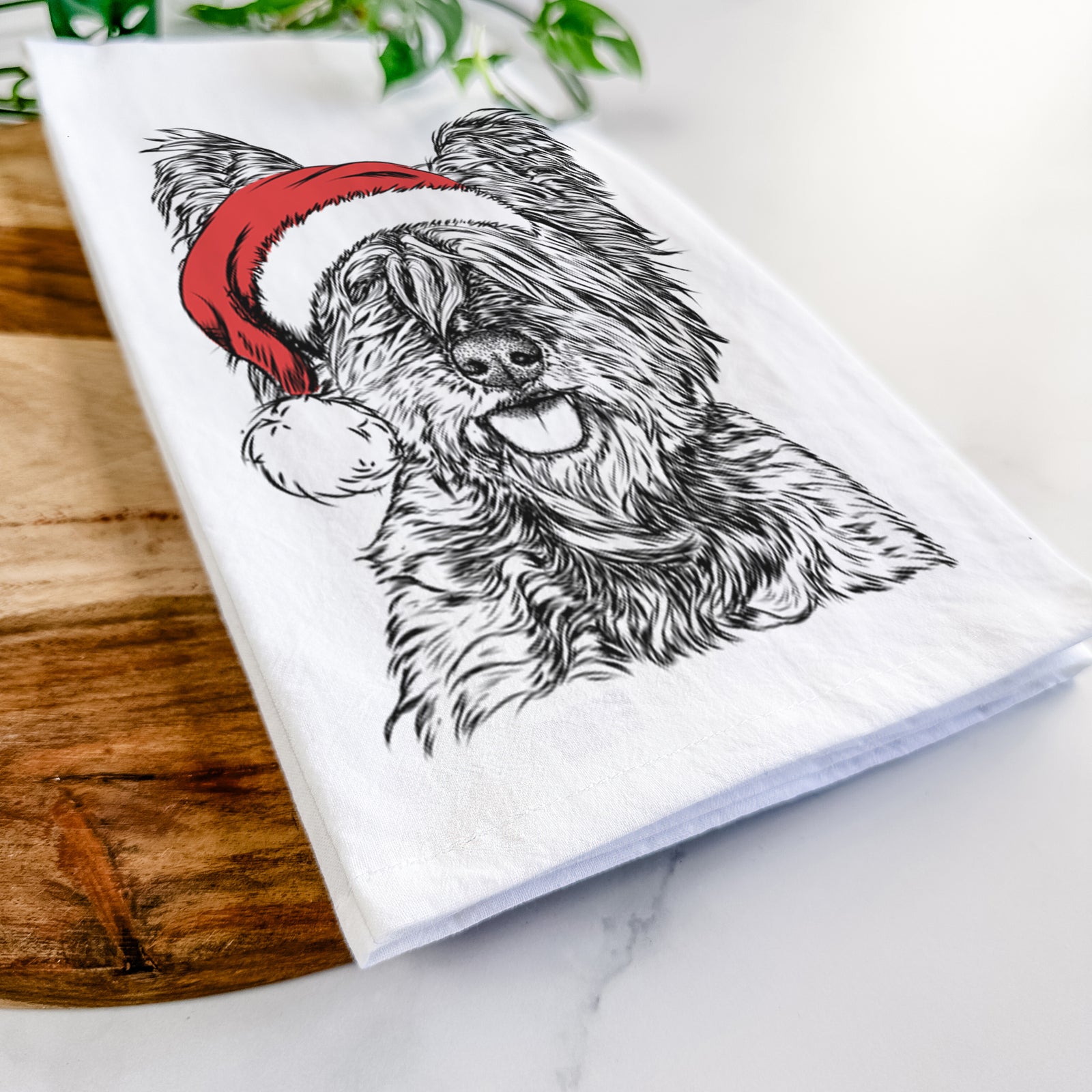 Hand-drawn sketch of McDuff the Cairn Terrier wearing a Santa hat on a tea towel