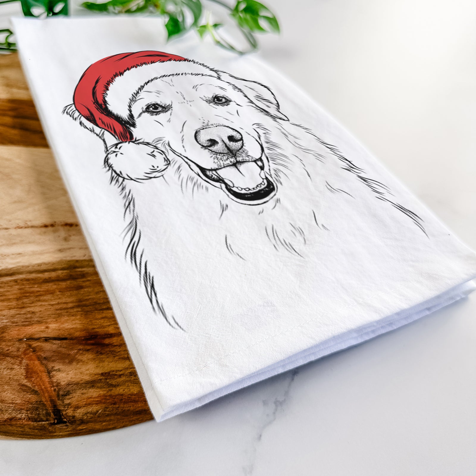 Hand-drawn sketch of Meg the Great Pyrenees wearing a Santa hat on a tea towel