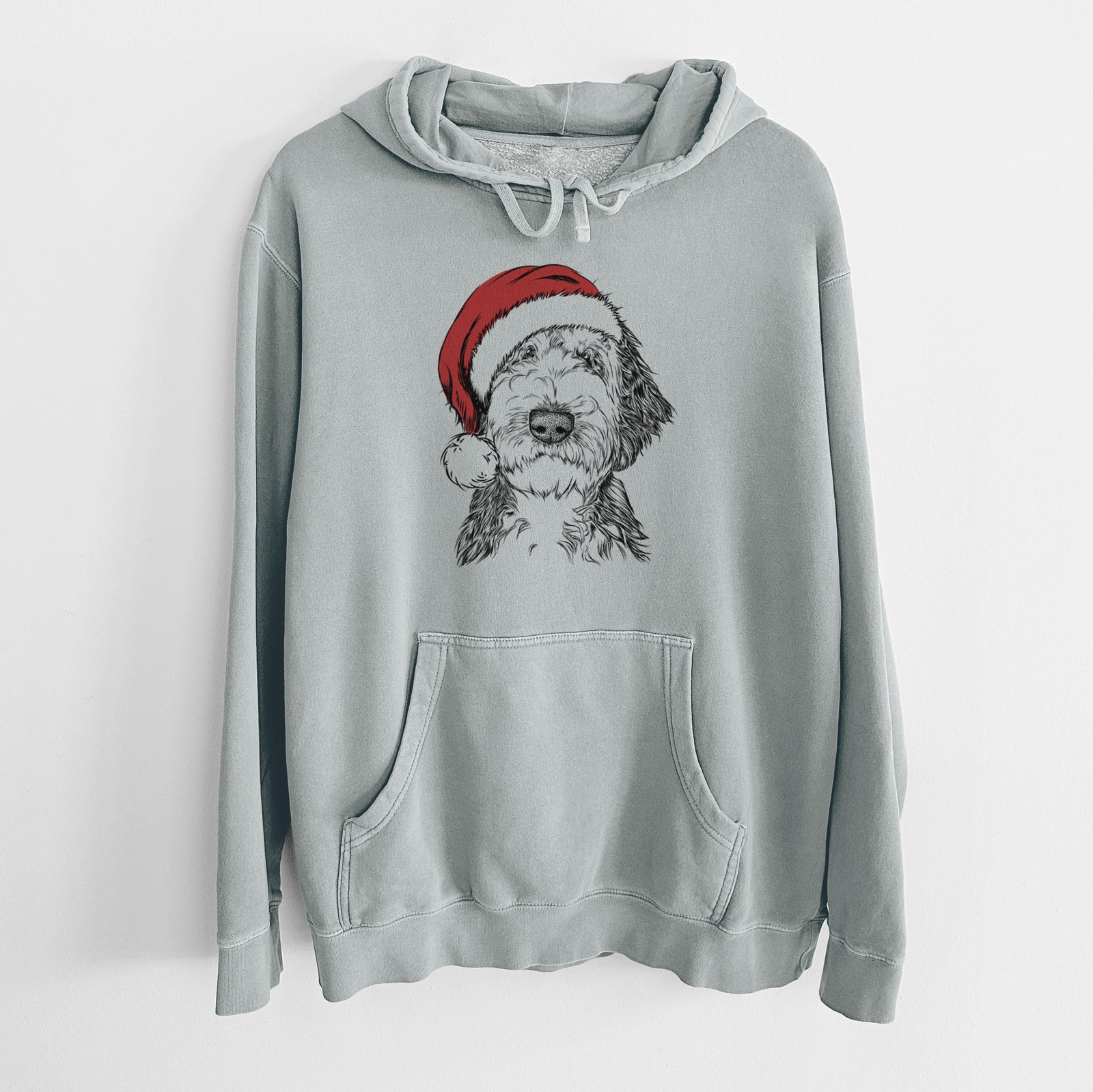 Hand-drawn sketch of Milo Fluff the Sheepadoodle wearing a Santa hat on a Sage Unisex pigment dyed hoodie