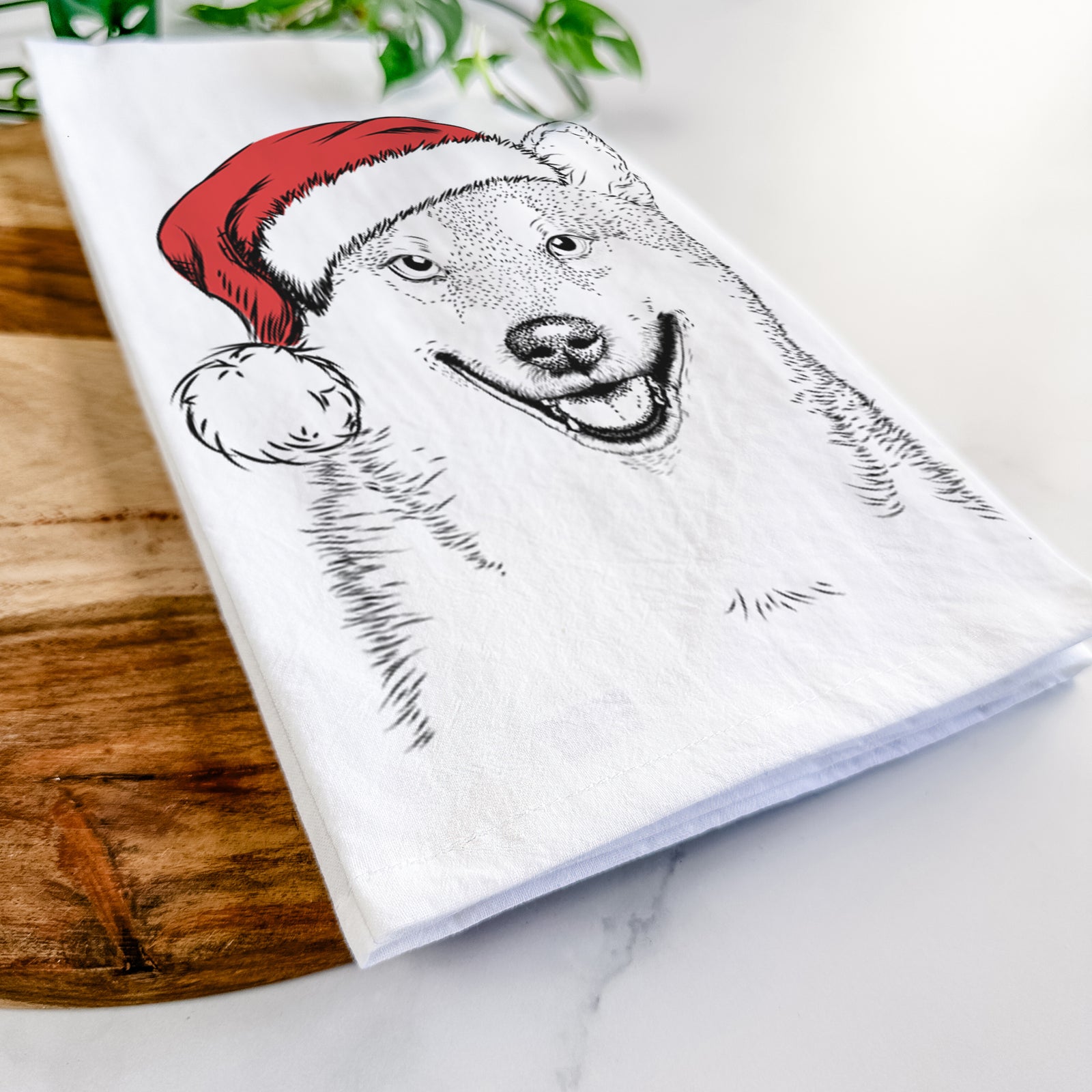 Hand-drawn sketch of Mitsu the Shiba Inu wearing a Santa hat on a tea towel
