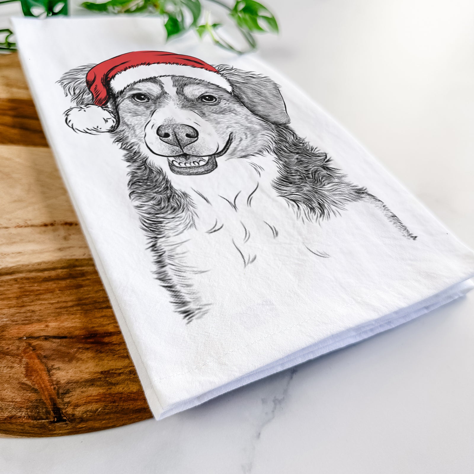 Hand-drawn sketch of Molly the Miniature Bernedoodle wearing a Santa hat on a tea towel