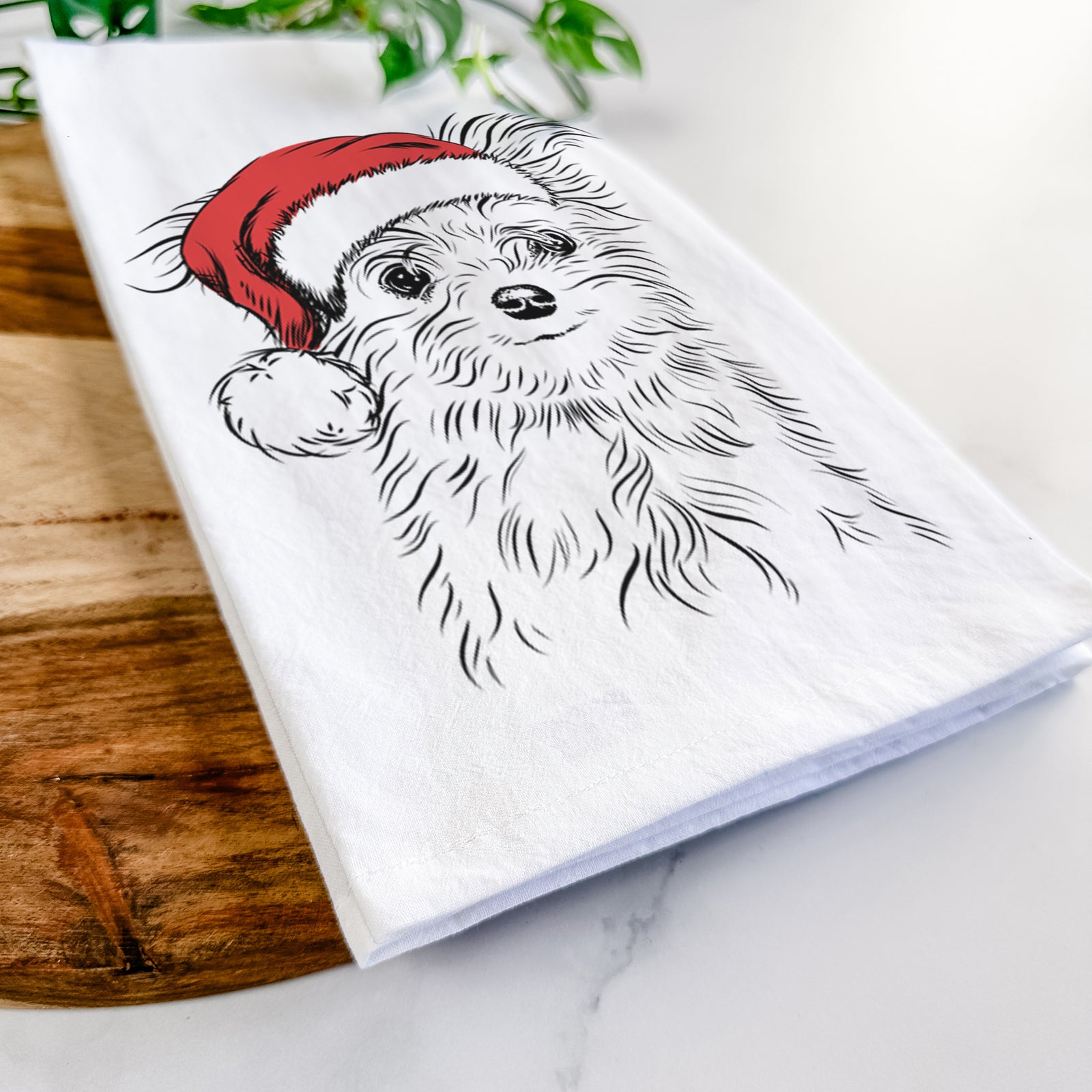Hand-drawn sketch of Mr. Gucci Poochi the Maltese wearing a Santa hat on a tea towel