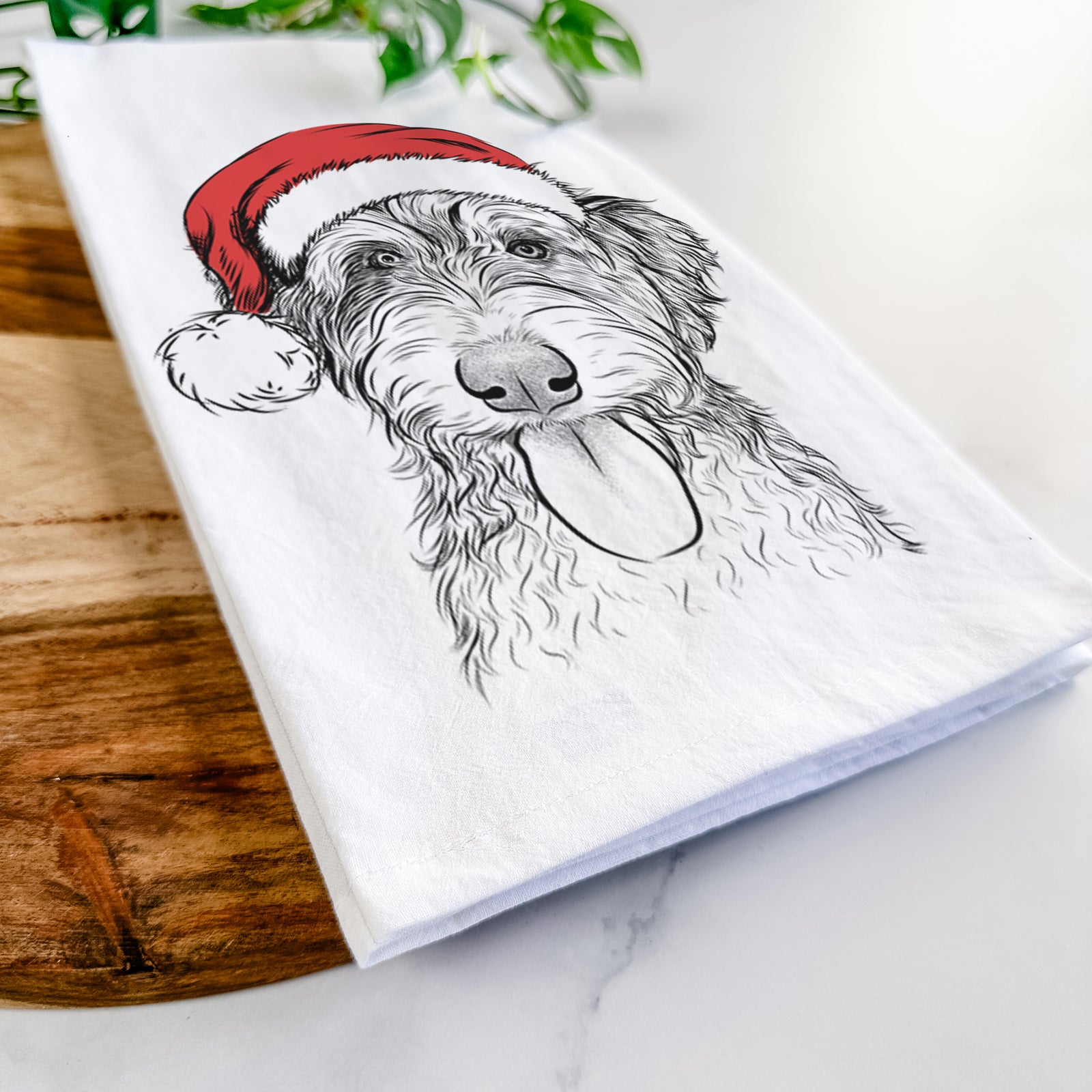 Hand-drawn sketch of Myrtle Mae the Aussiedoodle wearing a Santa hat on a tea towel