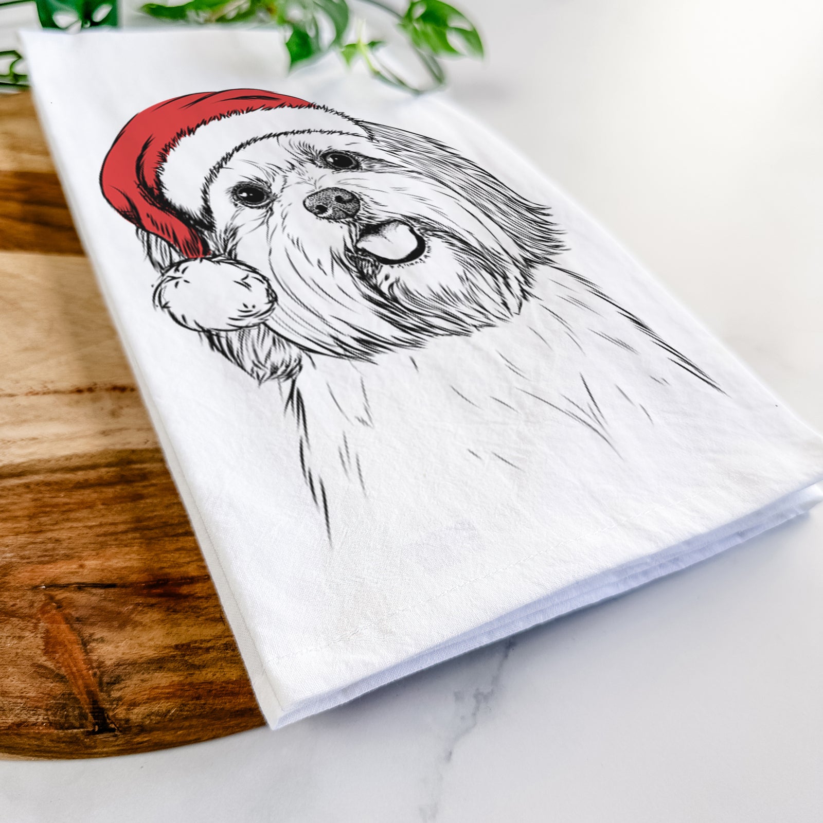 Hand-drawn sketch of Nikka the Lowchen wearing a Santa hat on a tea towel