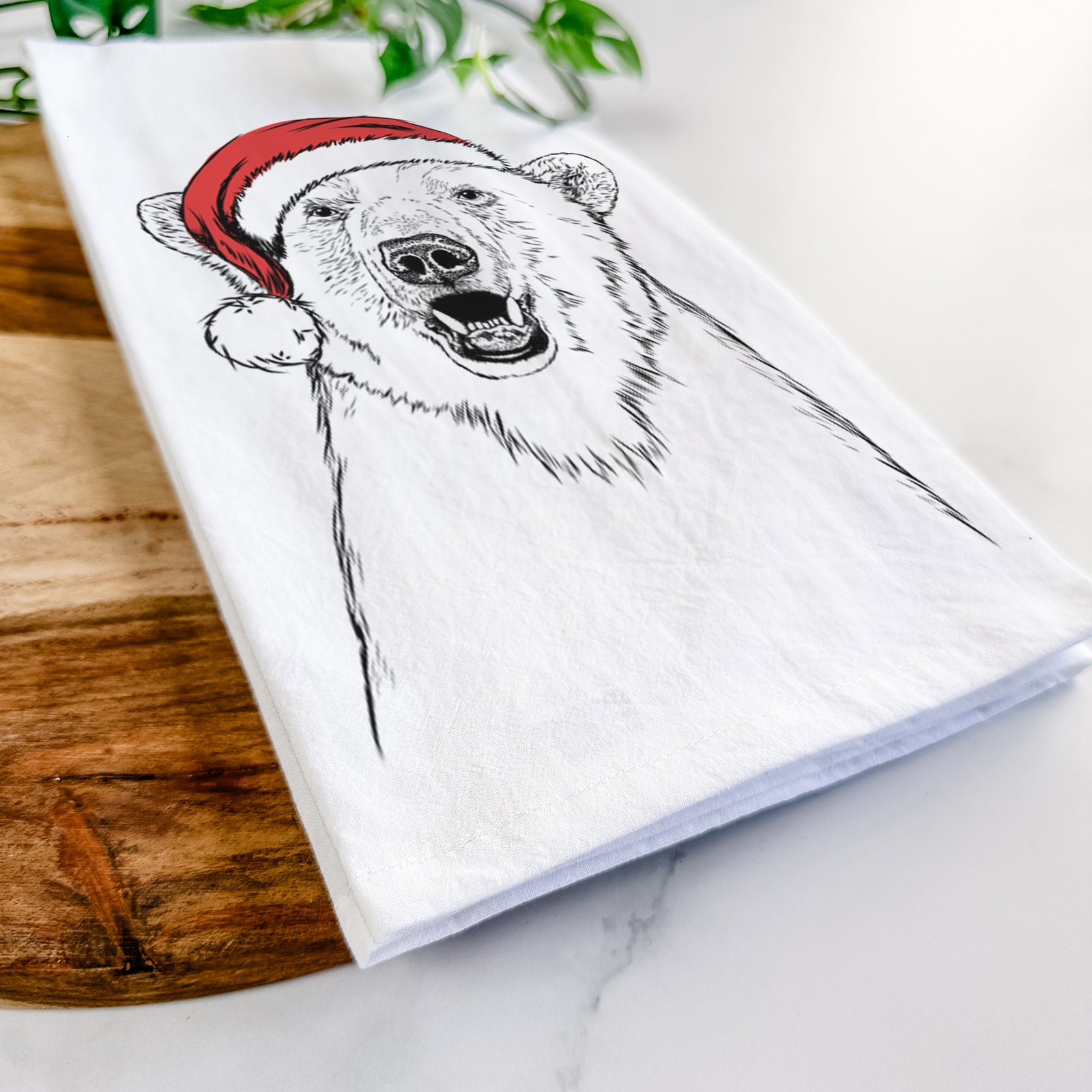 Hand-drawn sketch of Oslo the Polar Bear wearing a Santa hat on a tea towel