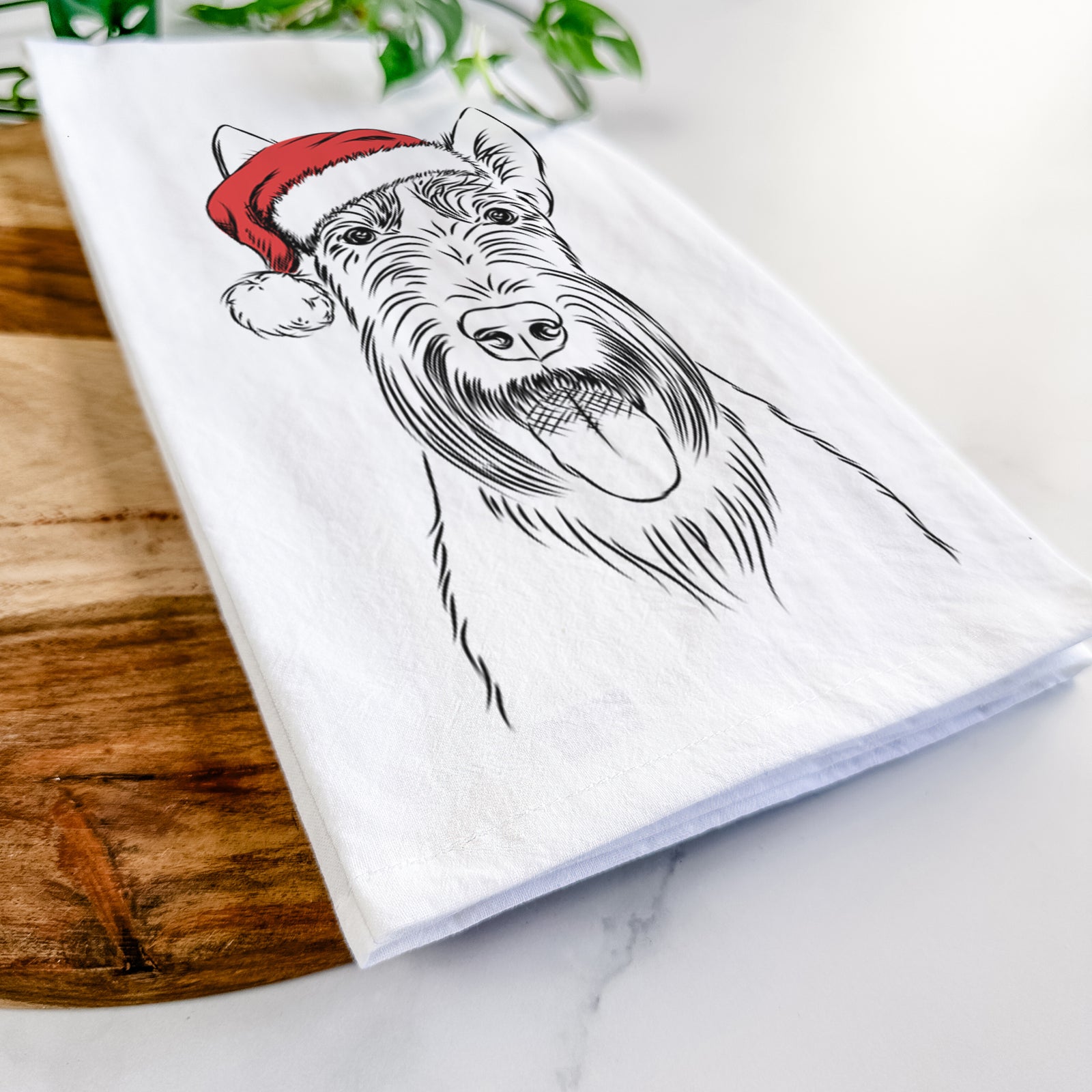 Hand-drawn sketch of Oswald the Scottish Terrier wearing a Santa hat on a tea towel