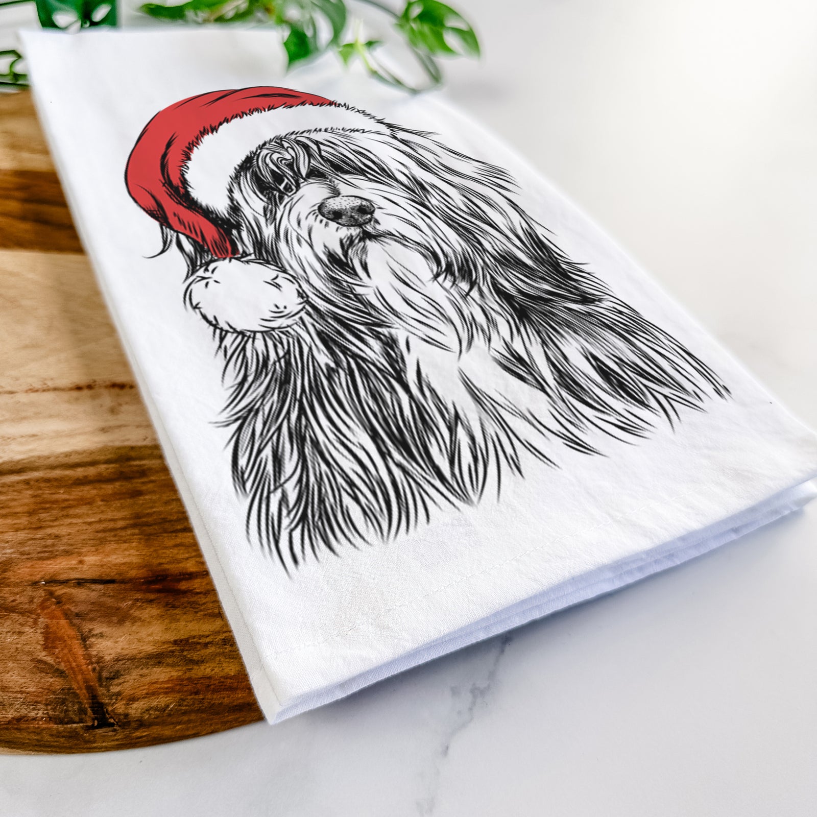 Hand-drawn sketch of Otto the Polish Lowland Sheepdog wearing a Santa hat on a tea towel