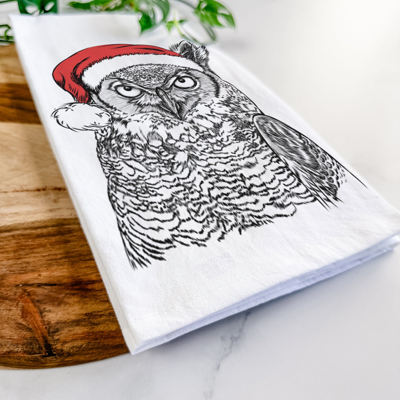 Hand-drawn sketch of Ozwald the Grey Horned Owl wearing a Santa hat on a tea towel