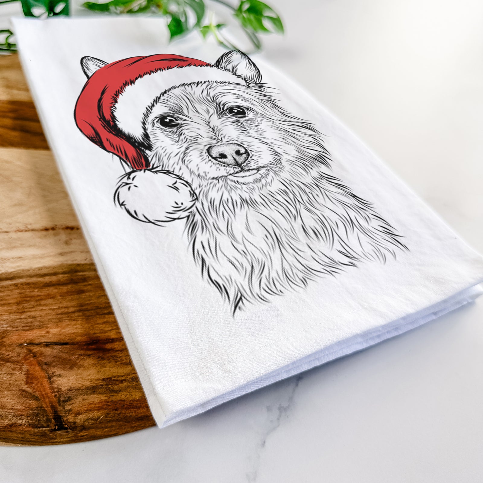 Hand-drawn sketch of Paulo the Portuguese Podengo wearing a Santa hat on a tea towel