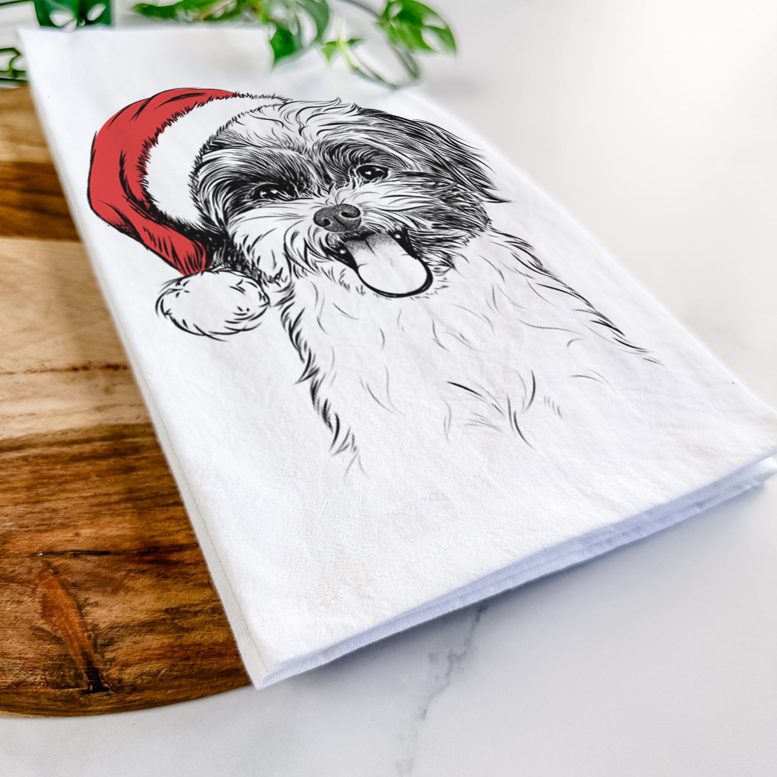 Hand-drawn sketch of Pepper the Shihpoo wearing a Santa hat on a tea towel