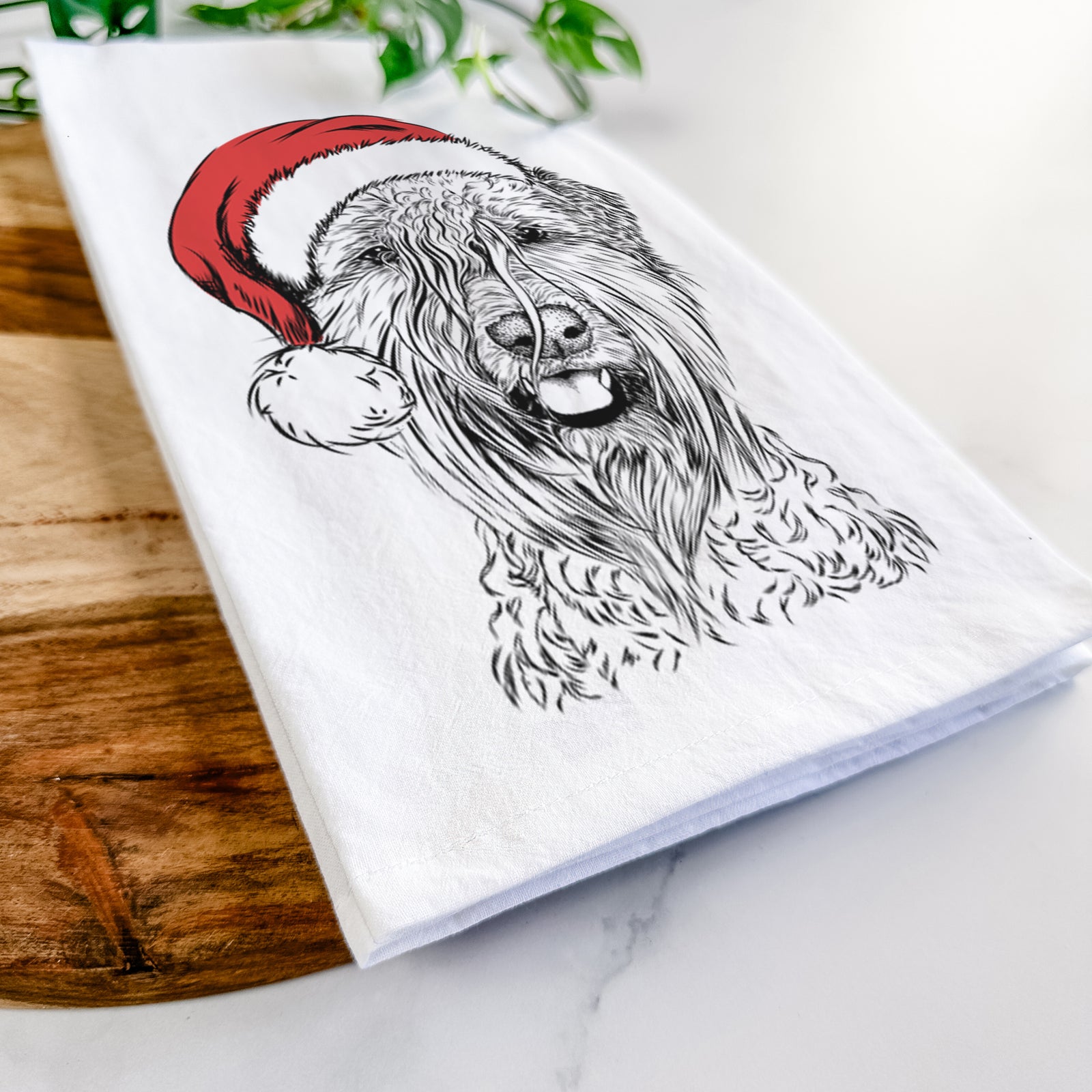 Hand-drawn sketch of Pierre the Soft Coated Wheaten Terrier wearing a Santa hat on a tea towel