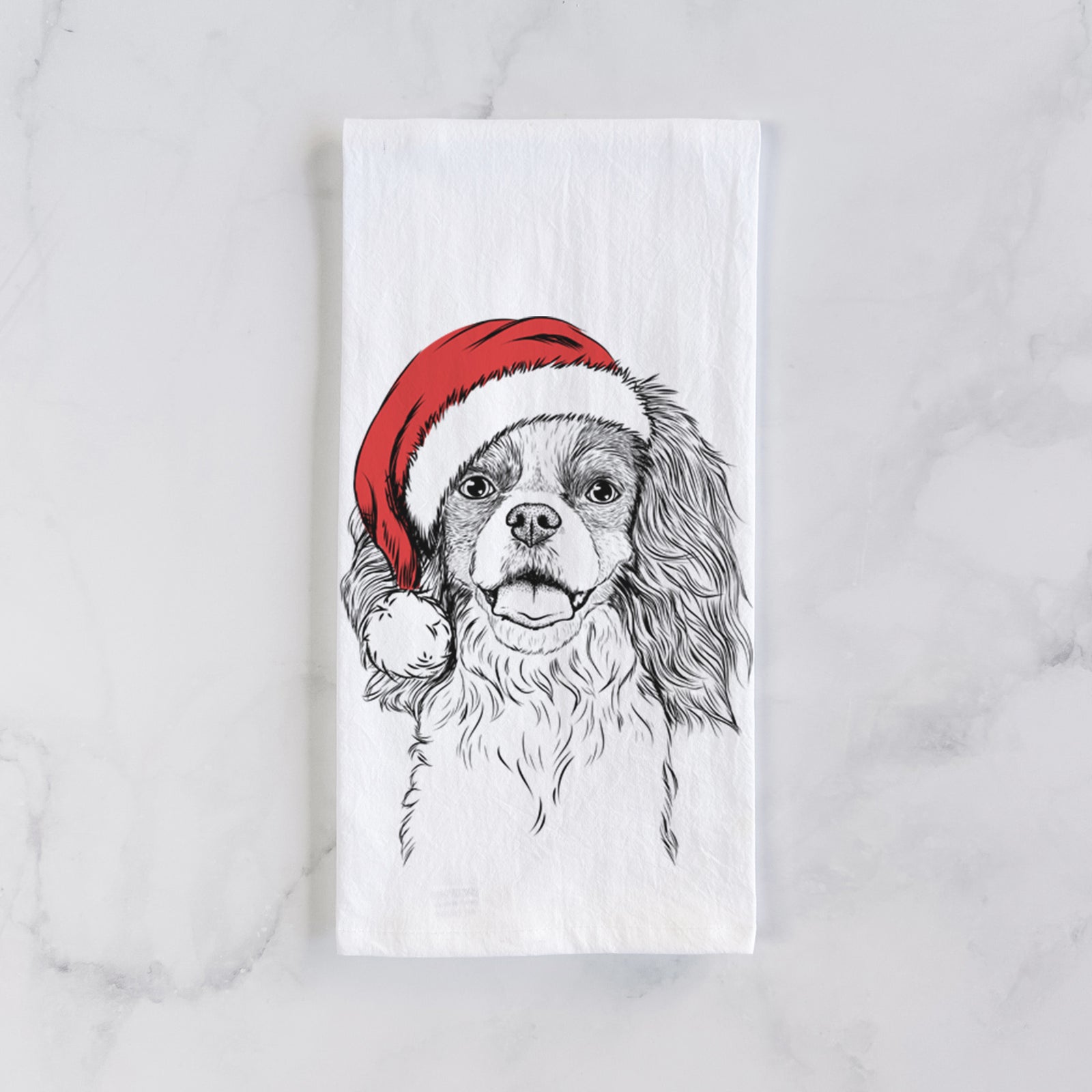 Hand-drawn sketch of Poppy the Cavalier King Charles Spaniel wearing a Santa hat on a tea towel