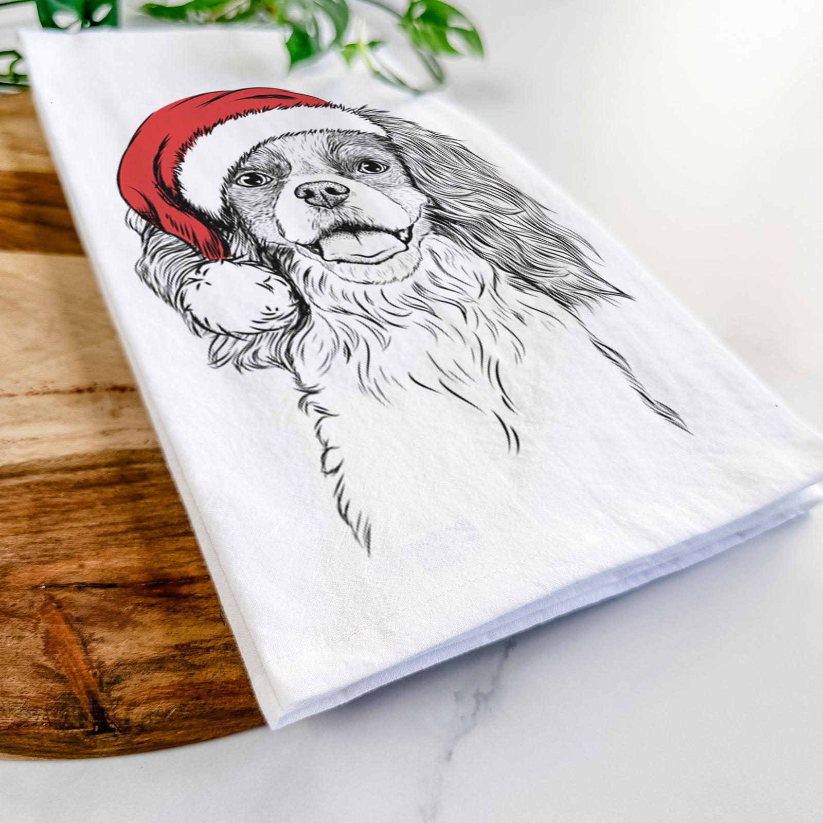 Hand-drawn sketch of Poppy the Cavalier King Charles Spaniel wearing a Santa hat on a tea towel