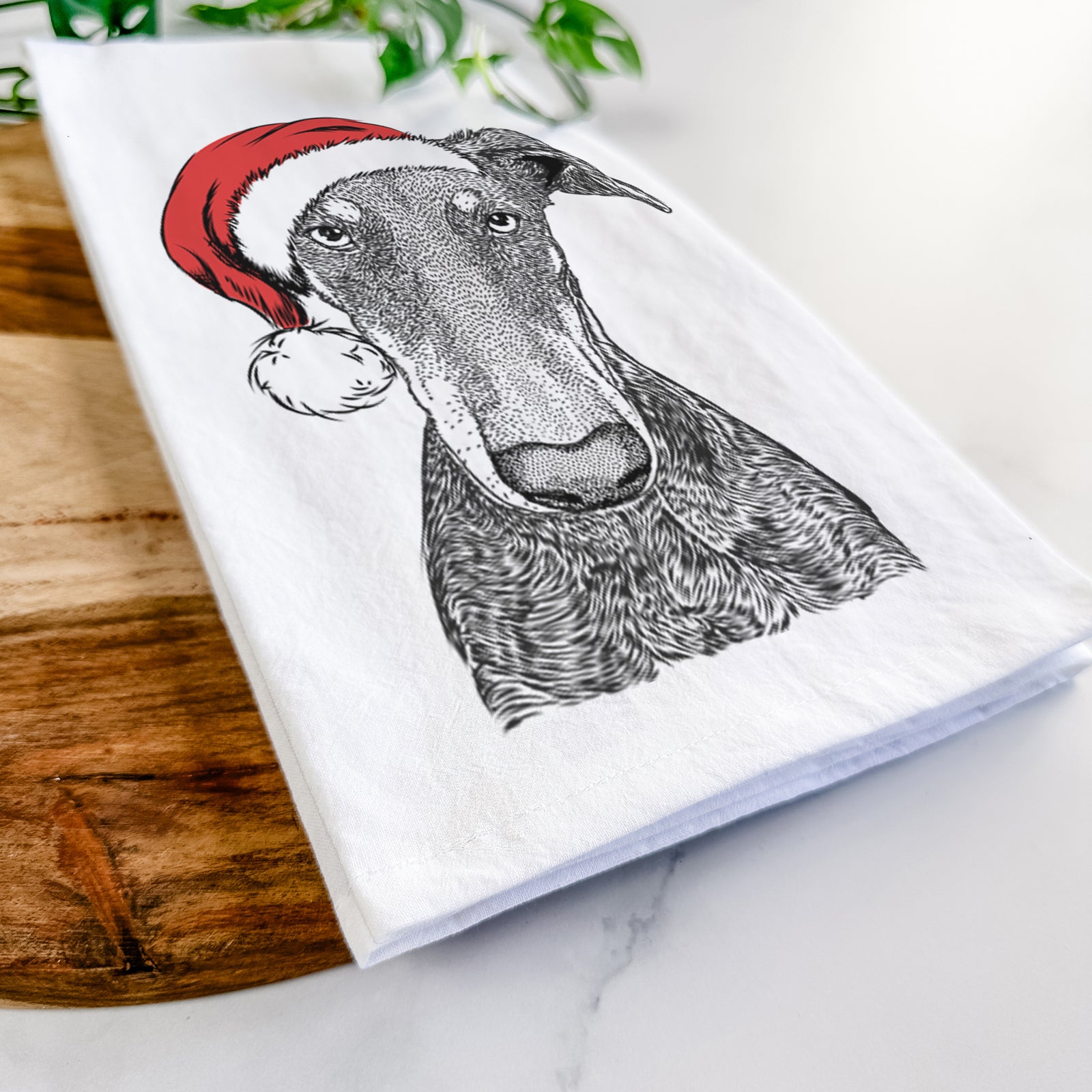 Hand-drawn sketch of Princess Fiona the Doberman Pinscher wearing a Santa hat on a tea towel